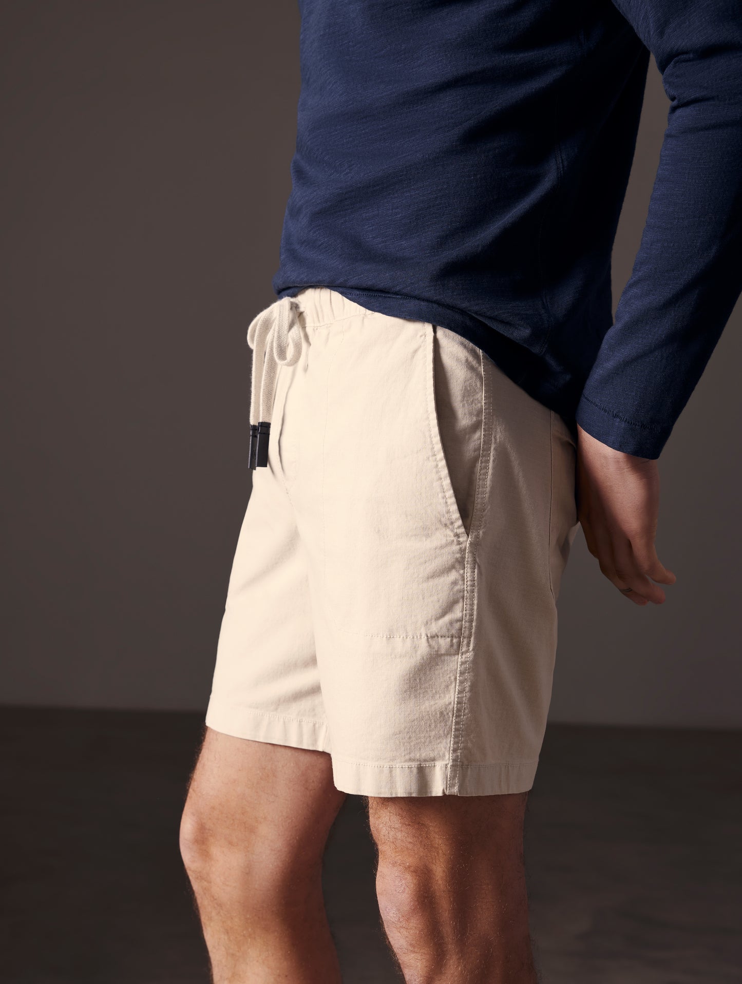 Side profile lower body view of man wearing Norton Cotton Ripstop Short in Bone white from AETHER Apparel.