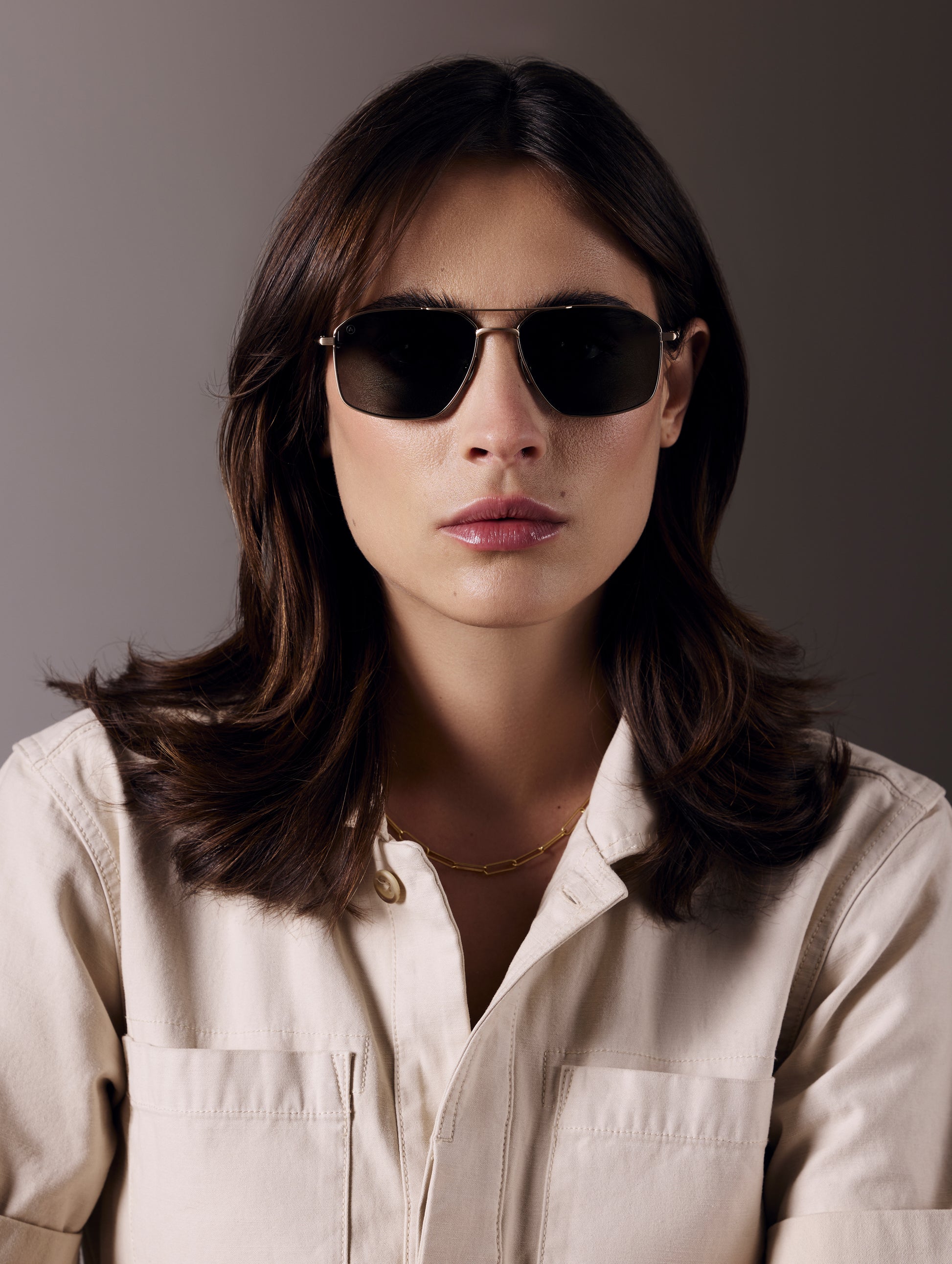 Front view of woman wearing Arches Sunglass in Brushed Gold with Deep G15 Lens from AETHER Apparel.