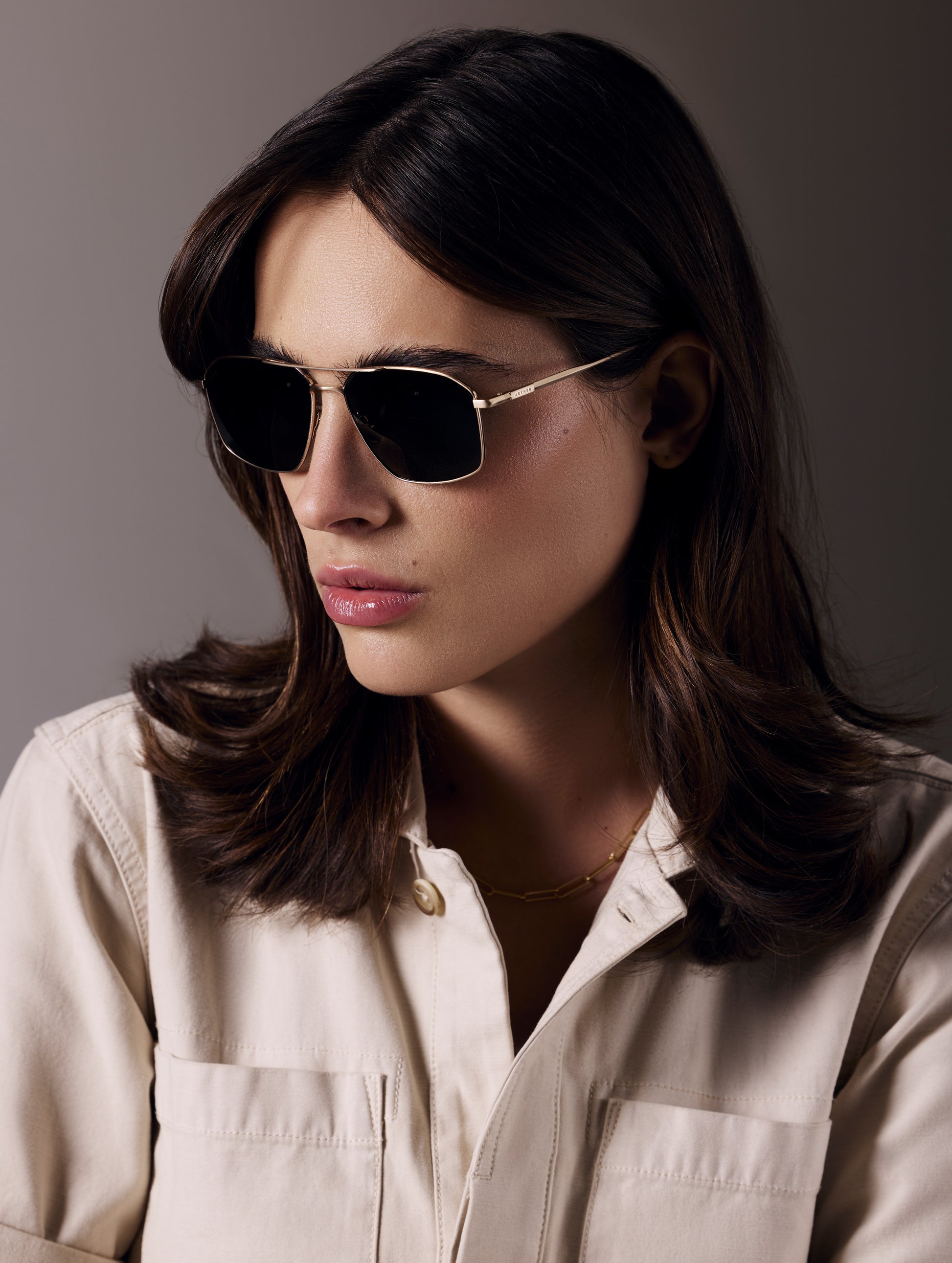 Front angled view of woman wearing Arches Sunglass in Brushed Gold with Deep G15 Lens from AETHER Apparel.