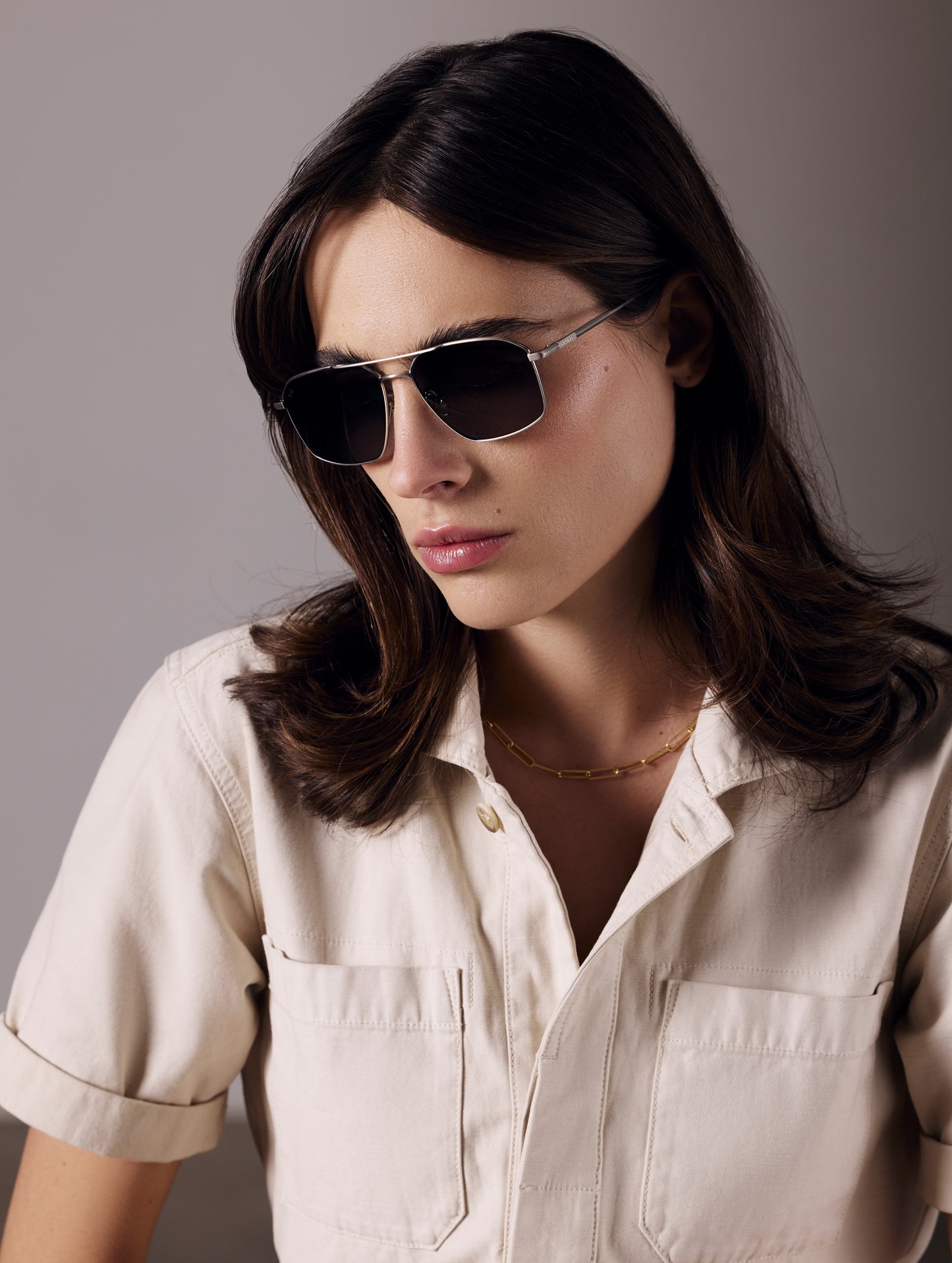 Front angled view of woman wearing Arches Sunglass in Brushed Silver with Grey Lens from AETHER Apparel.