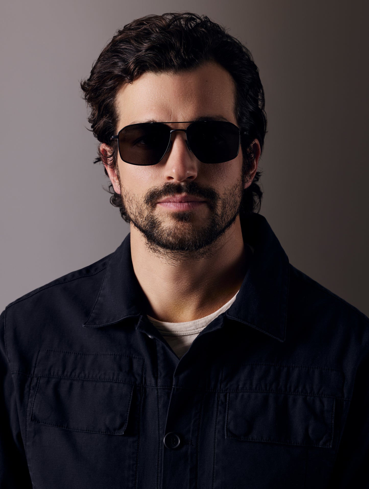 Front view of man wearing Arches Sunglass in Black with Black Lens from AETHER Apparel.