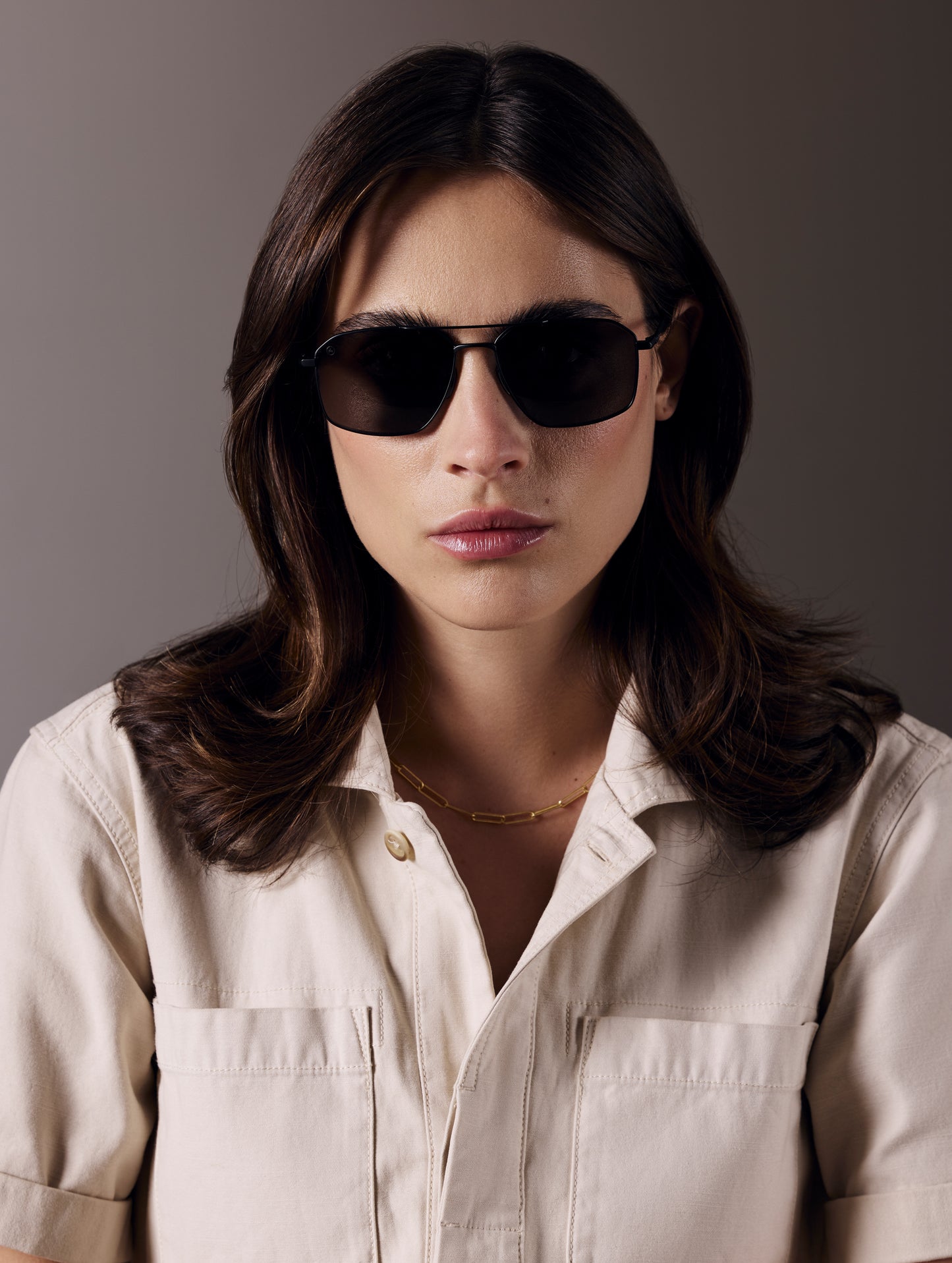 Front view of woman wearing Arches Sunglass in Black with Black Lens from AETHER Apparel.
