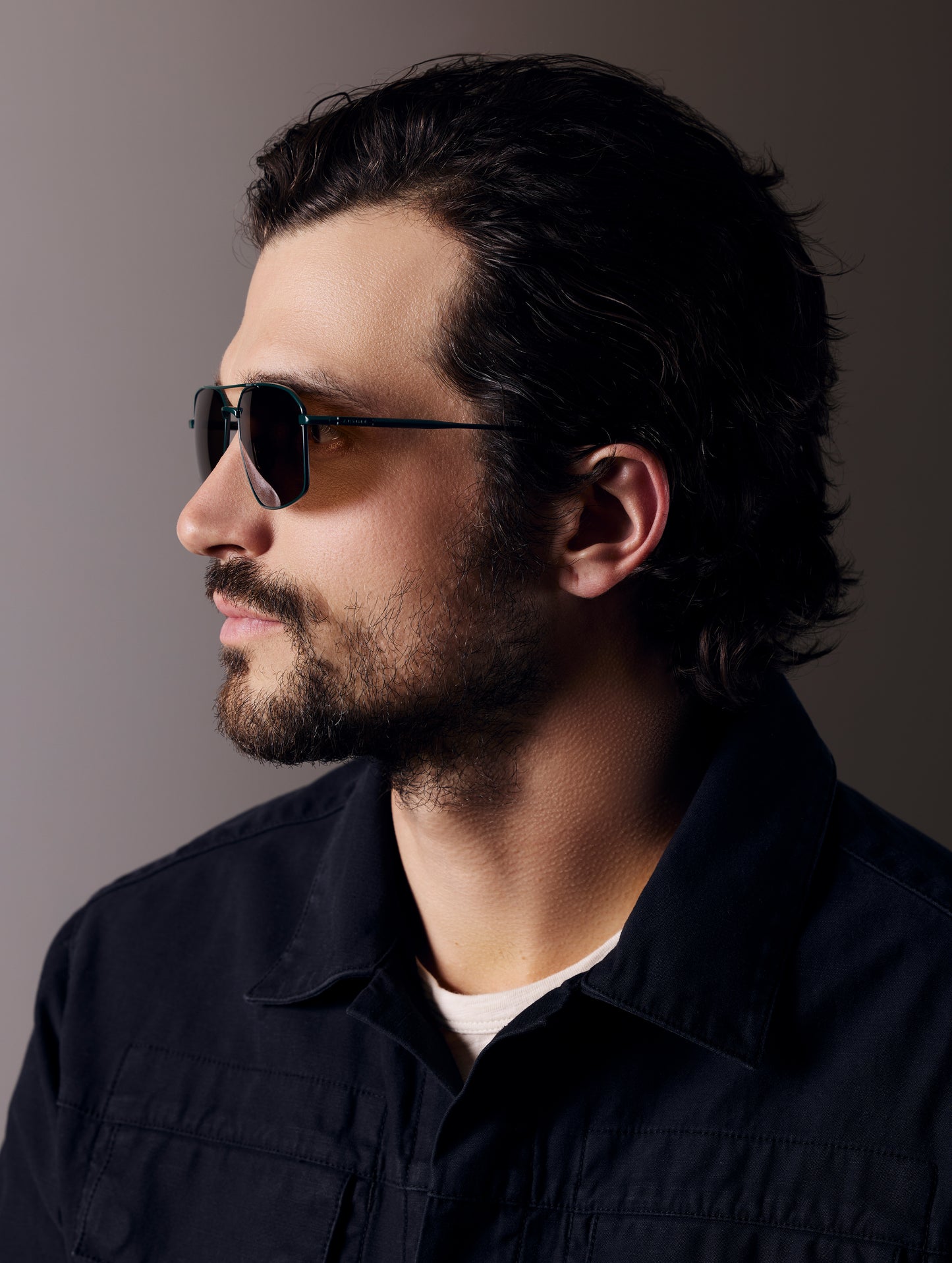 Front angled view of man wearing Arches Sunglass in Green with Brown Lens from AETHER Apparel.