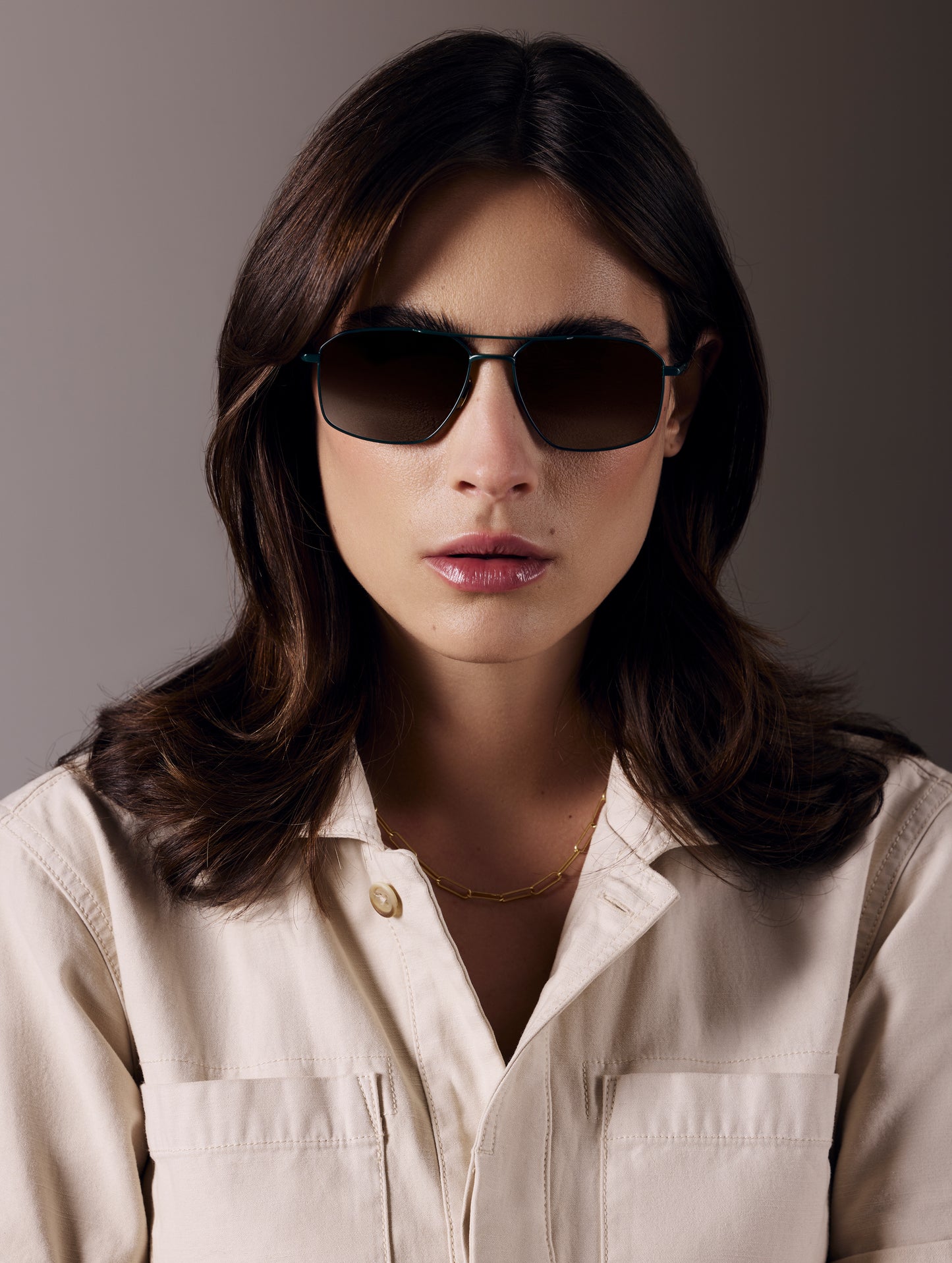 Front view of woman wearing Arches Sunglass in Green with Brown Lens from AETHER Apparel.