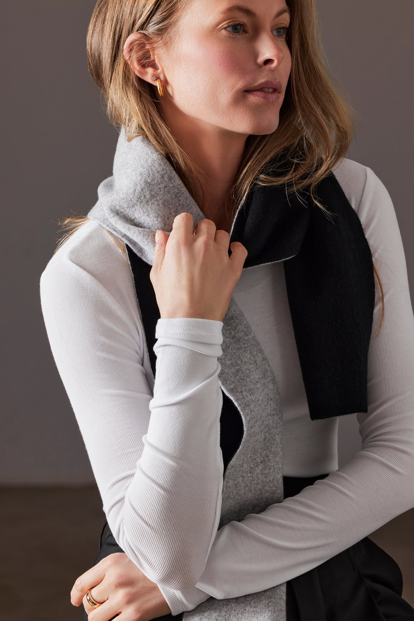 Front angled view of woman wearing Avesta Cashmere Scarf in Light Heather Grey from AETHER Apparel.