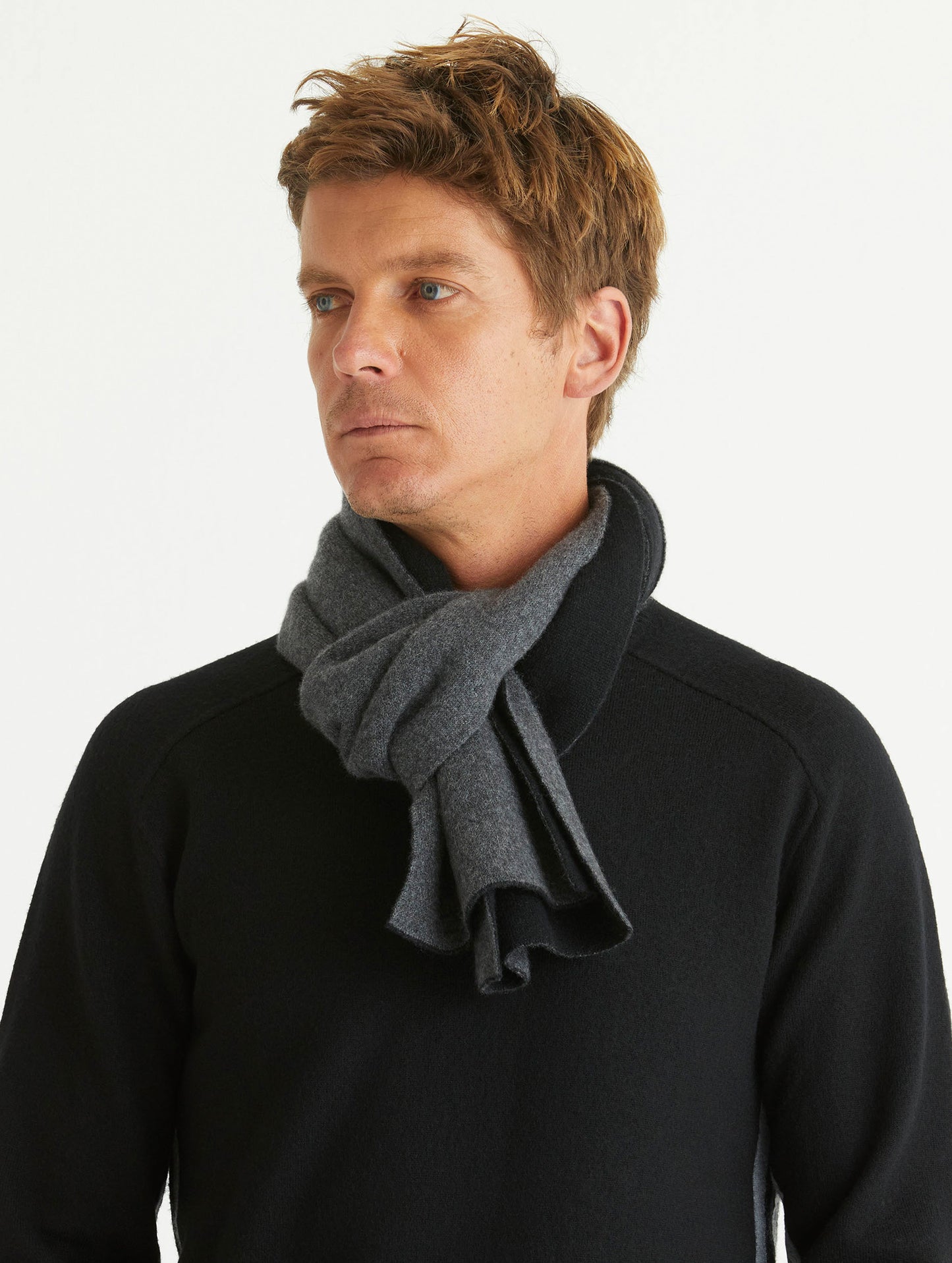 Front view of man wearing Avesta Cashmere Scarf in Onyx Black from AETHER Apparel.