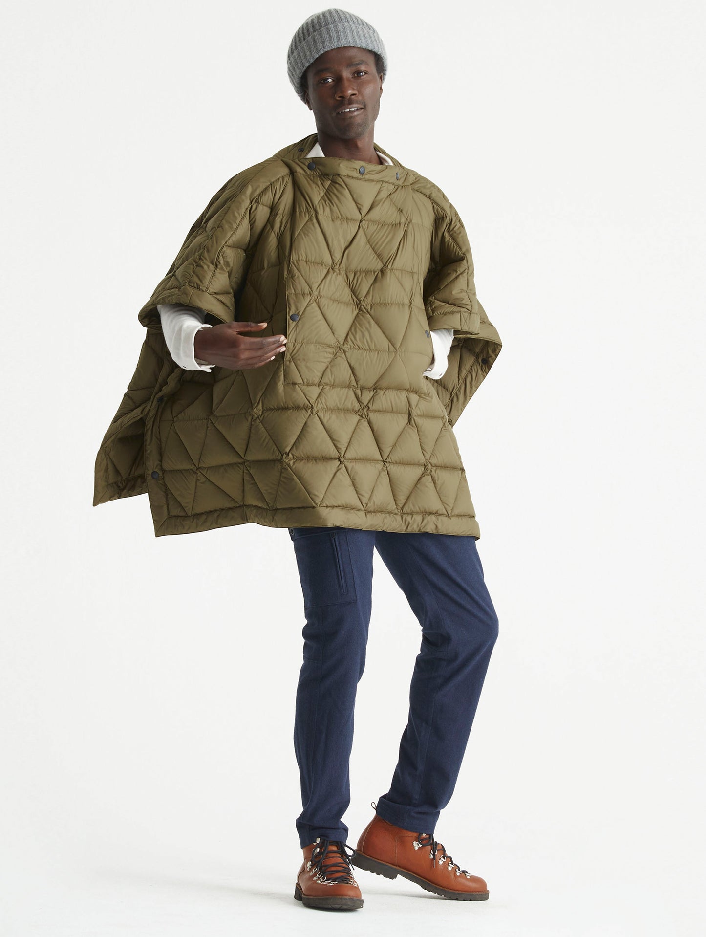Front 3/4 full-body view of man wearing Down Poncho in Command Green from AETHER Apparel.