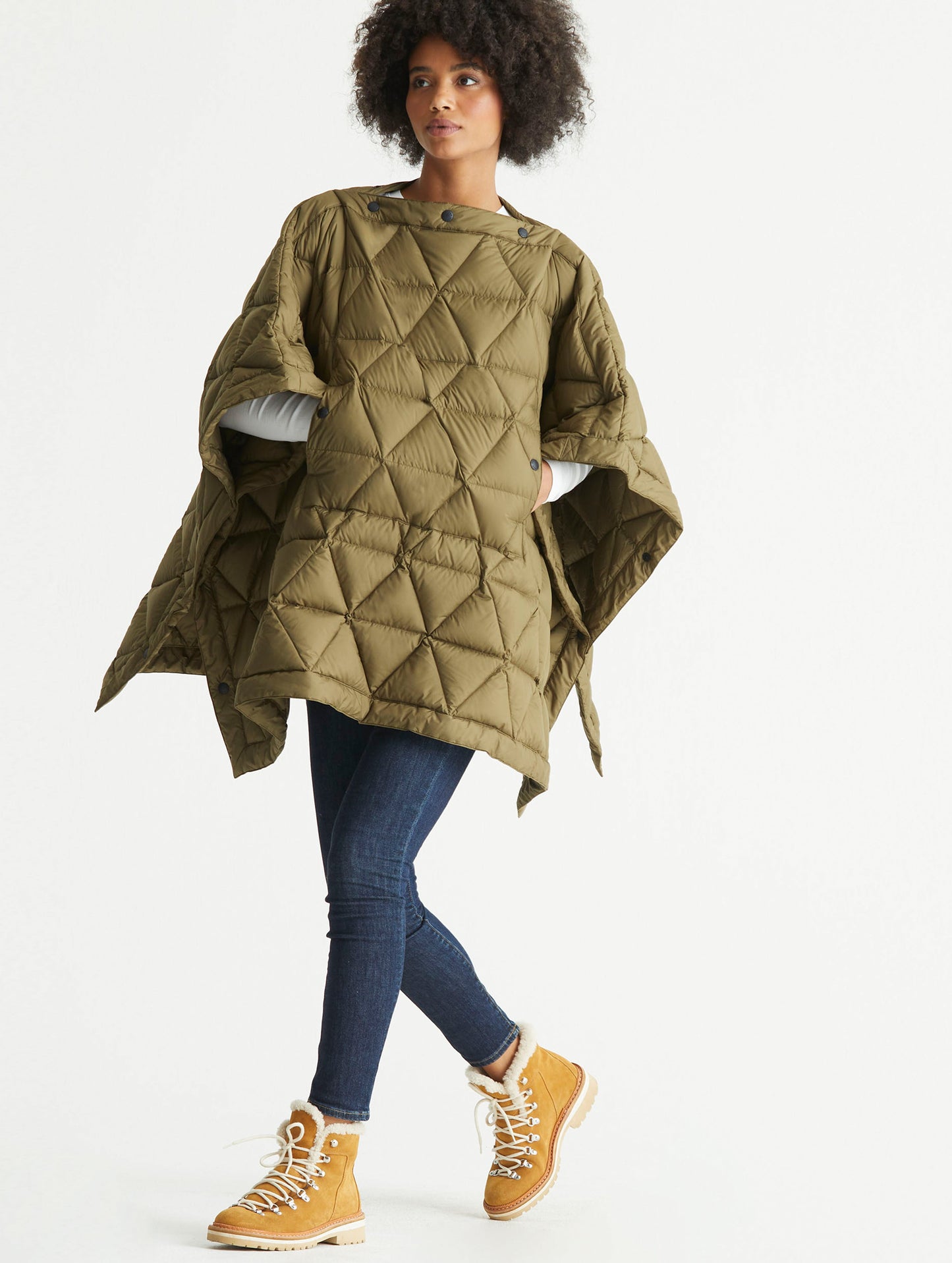 Front 3/4 full-body view of woman wearing Down Poncho in Command Green from AETHER Apparel.