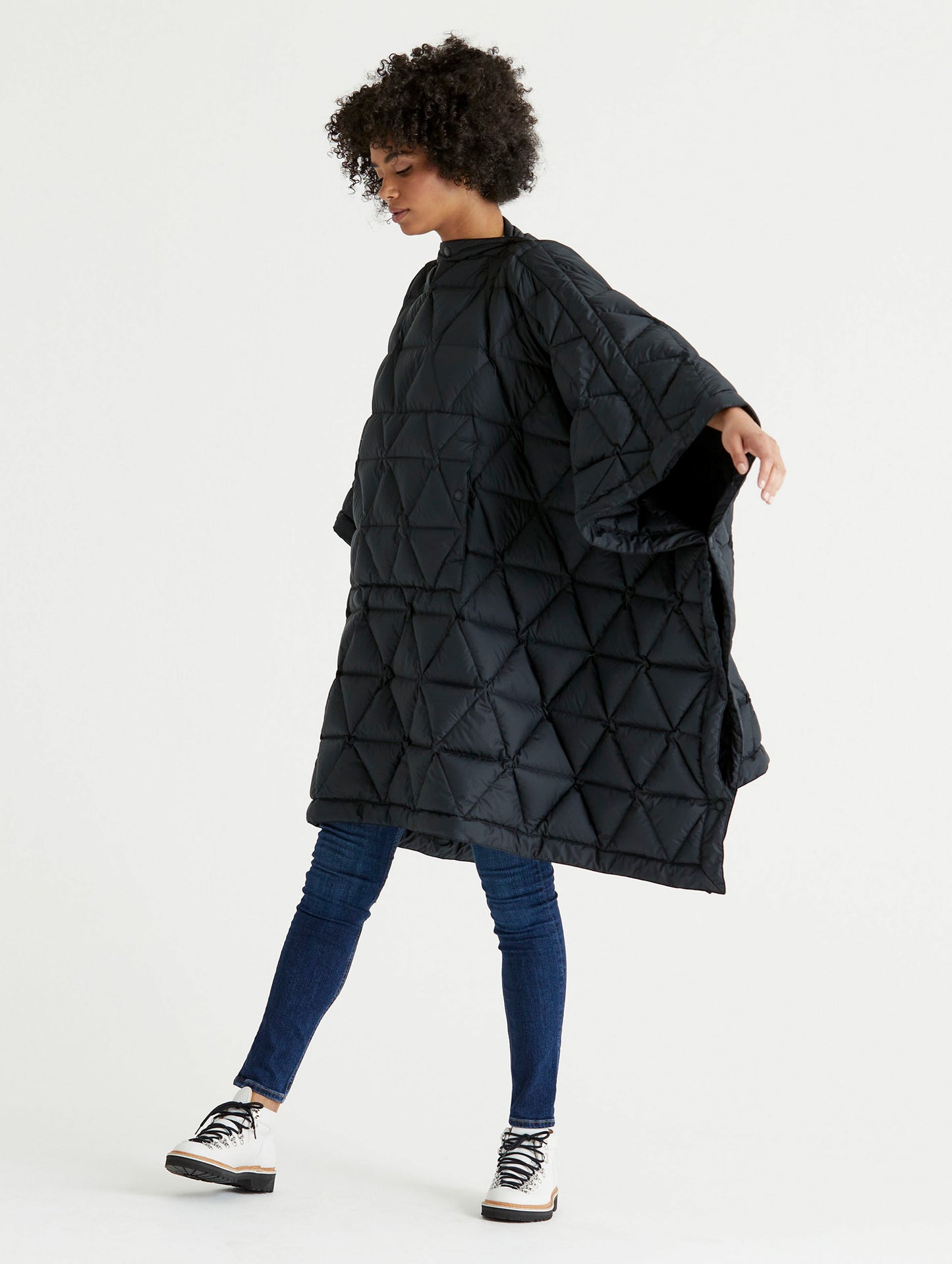 Front 3/4 full-body view of woman wearing Down Poncho in Onyx Black from AETHER Apparel.