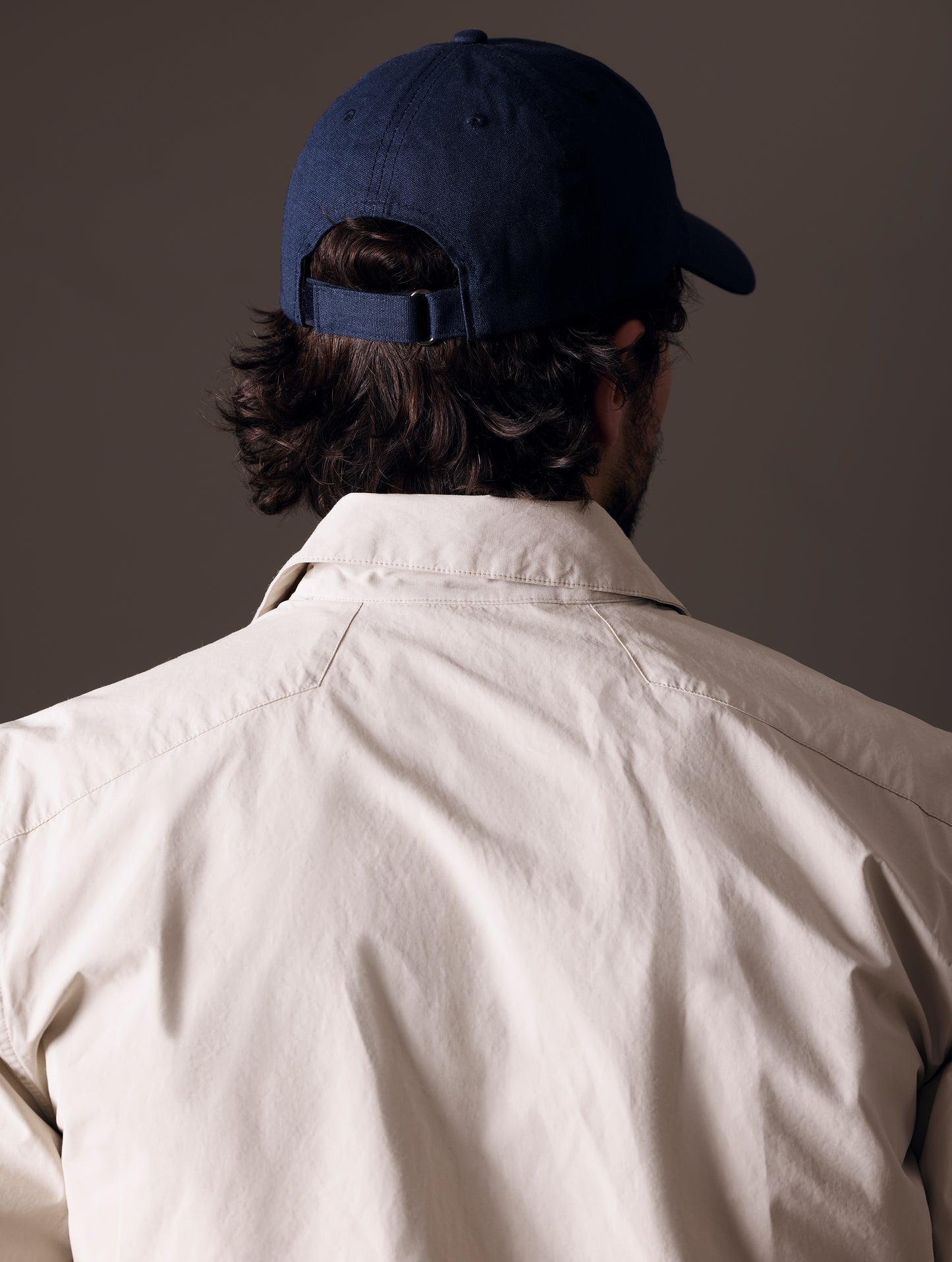 Rear angled view of man wearing AETHER Mountain Hat in Nordic Navy blue from AETHER Apparel.