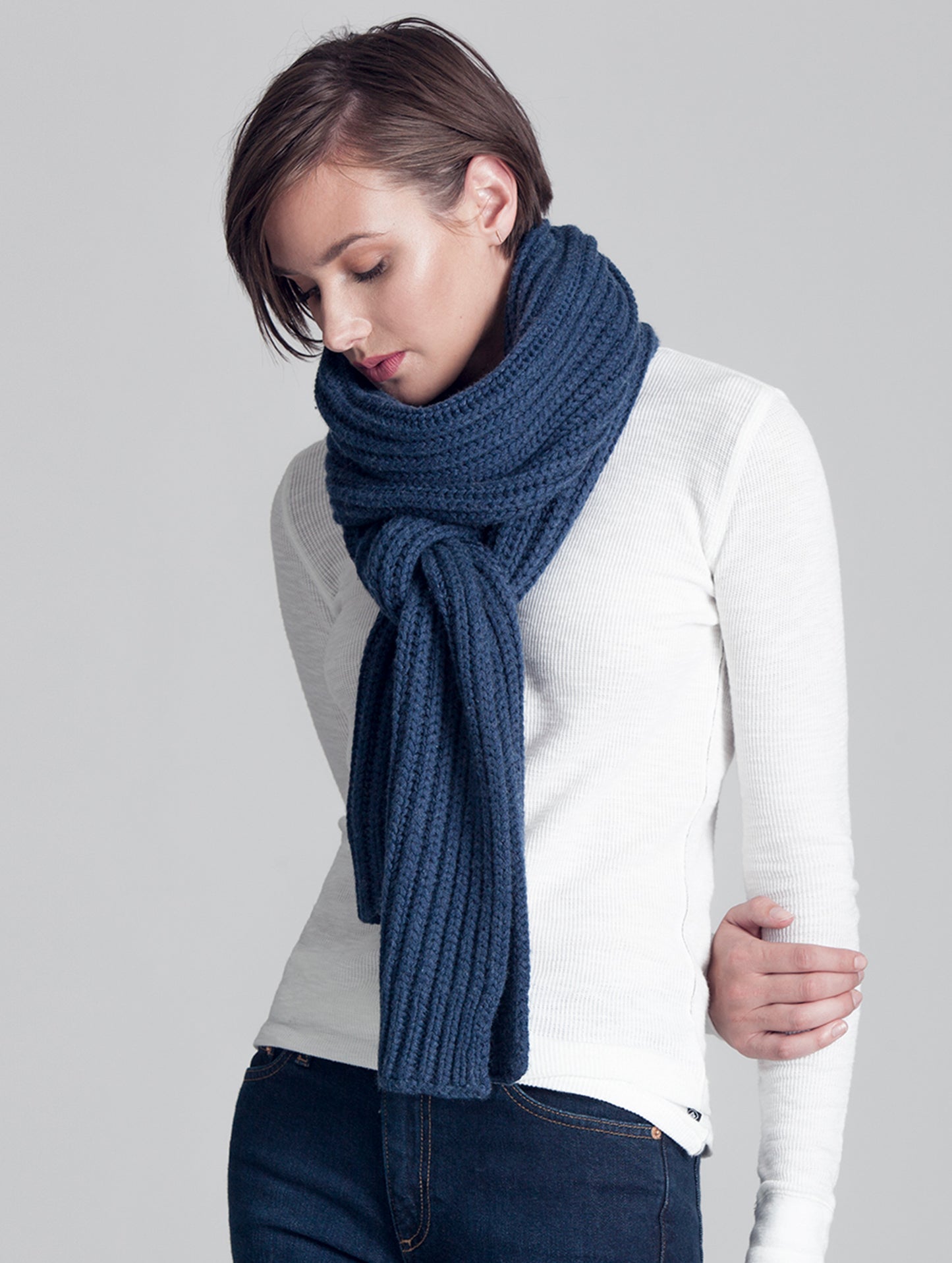 Woman wearing knotted blue Seasons Scarf from AETHER Apparel.