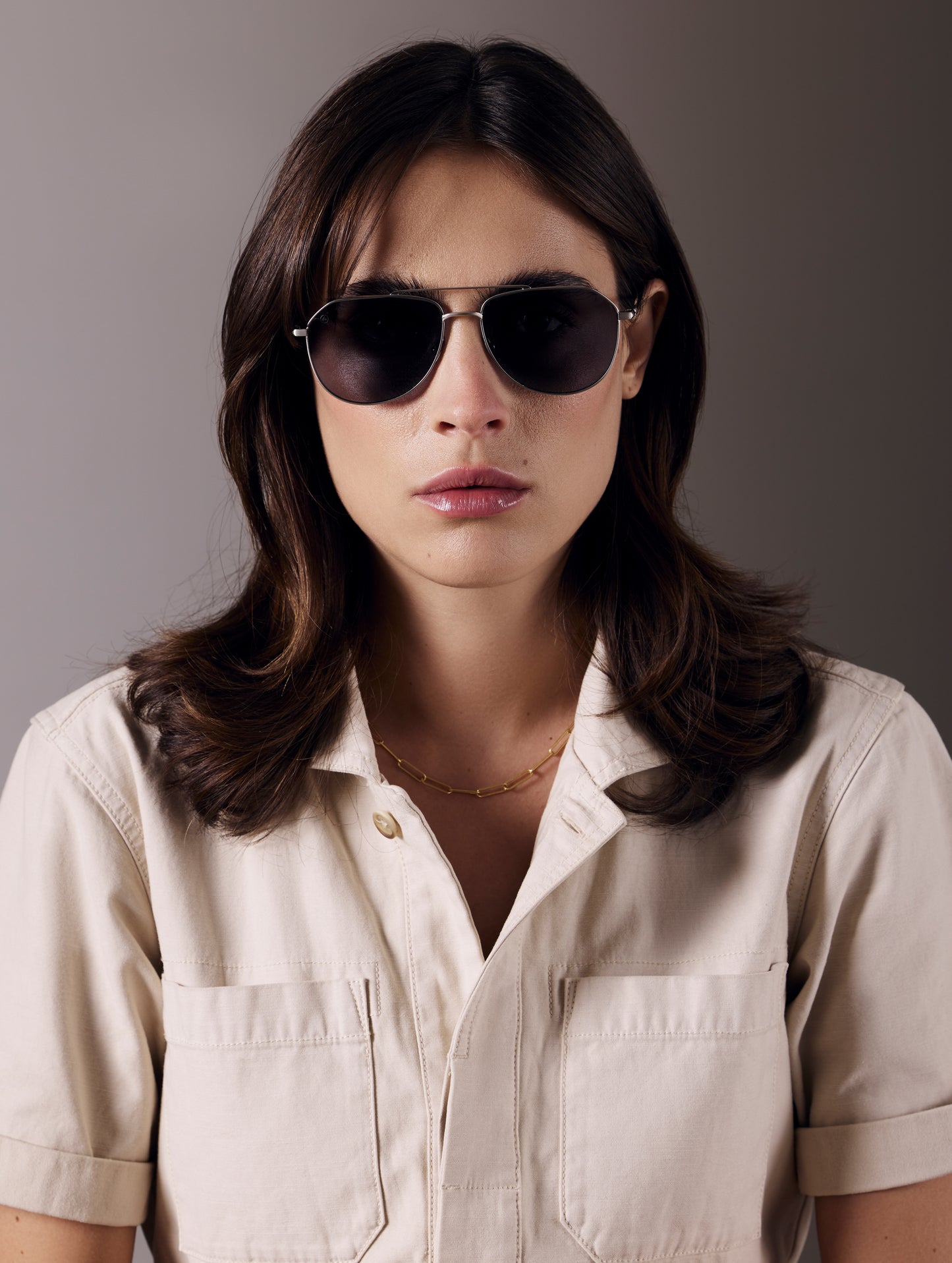 Front view of woman wearing Bryce Sunglass in Brushed Silver titanium with Grey Lens from AETHER Apparel.