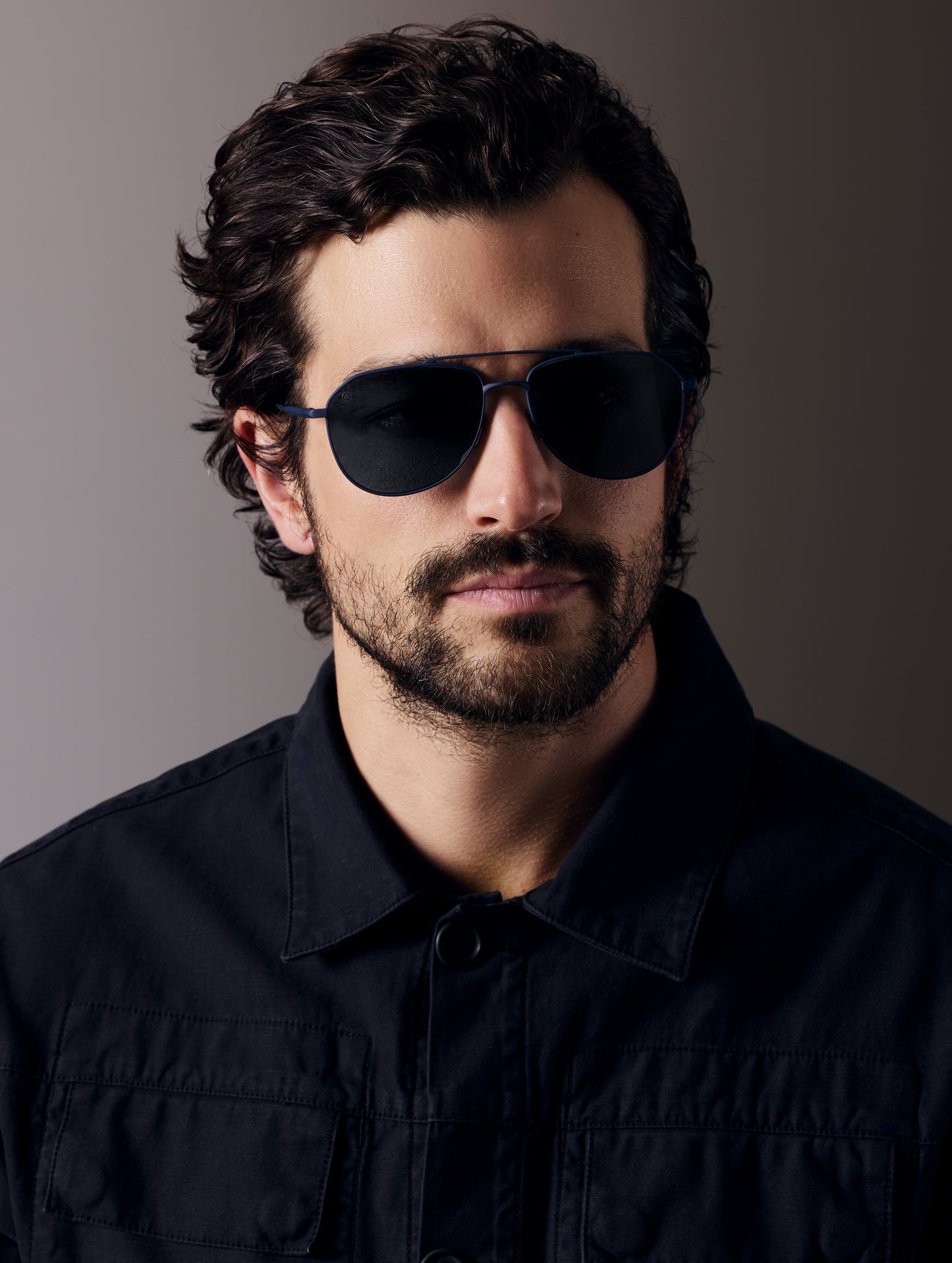Front view of man wearing Bryce Sunglass in black titanium with Blue Lens from AETHER Apparel.