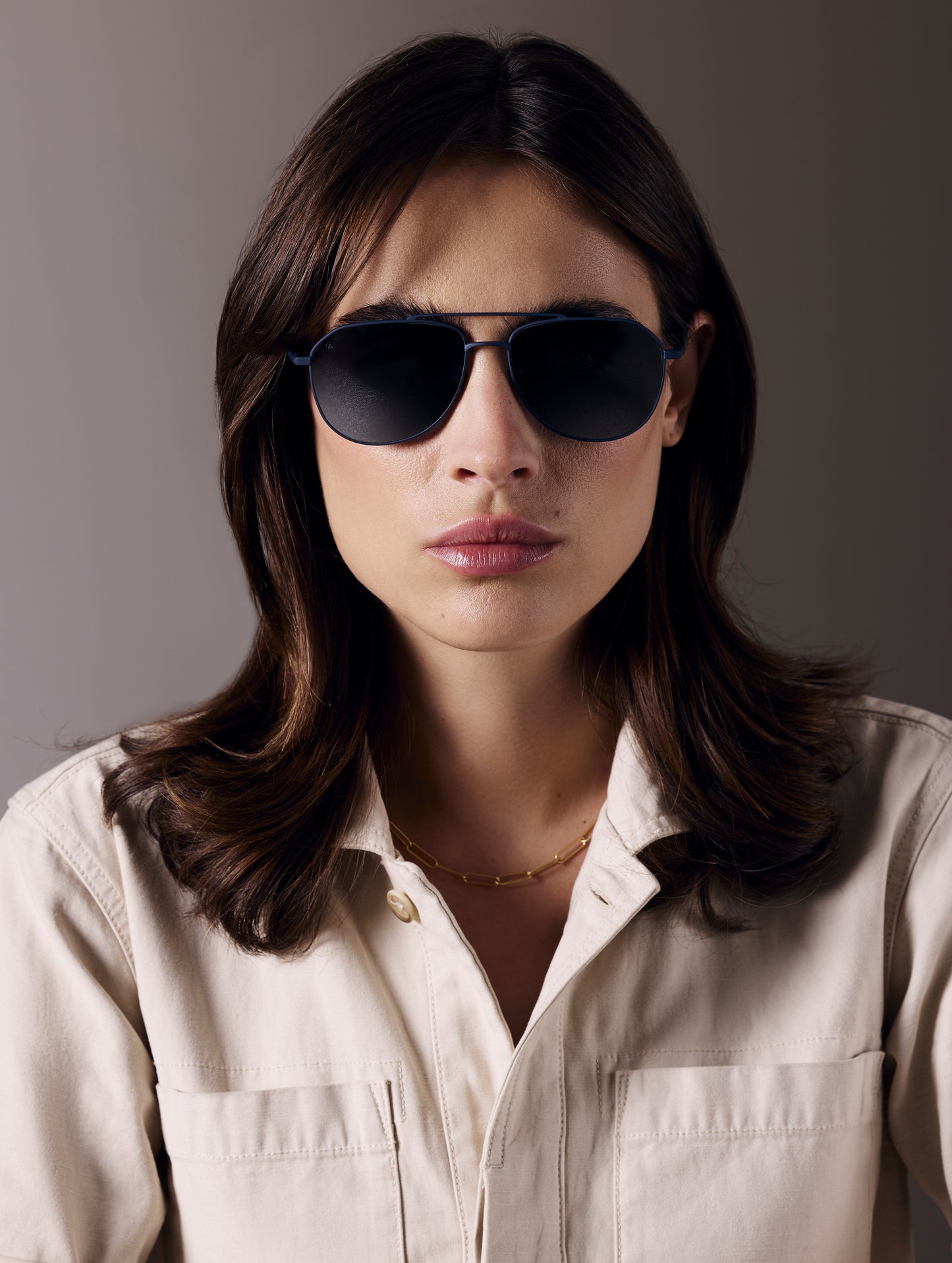 Front view of woman wearing Bryce Sunglass in black titanium with Blue Lens from AETHER Apparel.