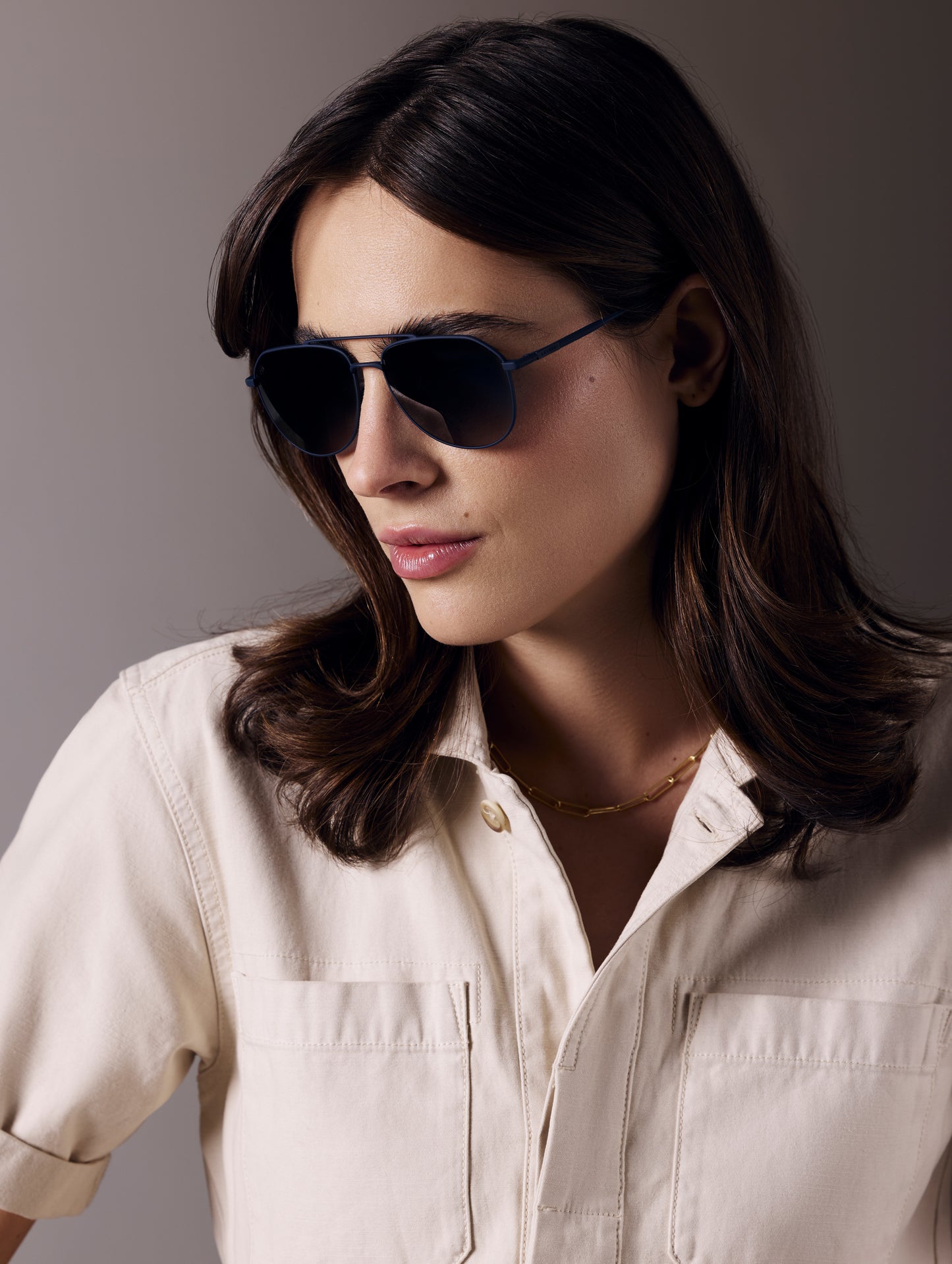 Front 3/4 view of woman wearing Bryce Sunglass in black titanium with Blue Lens from AETHER Apparel.