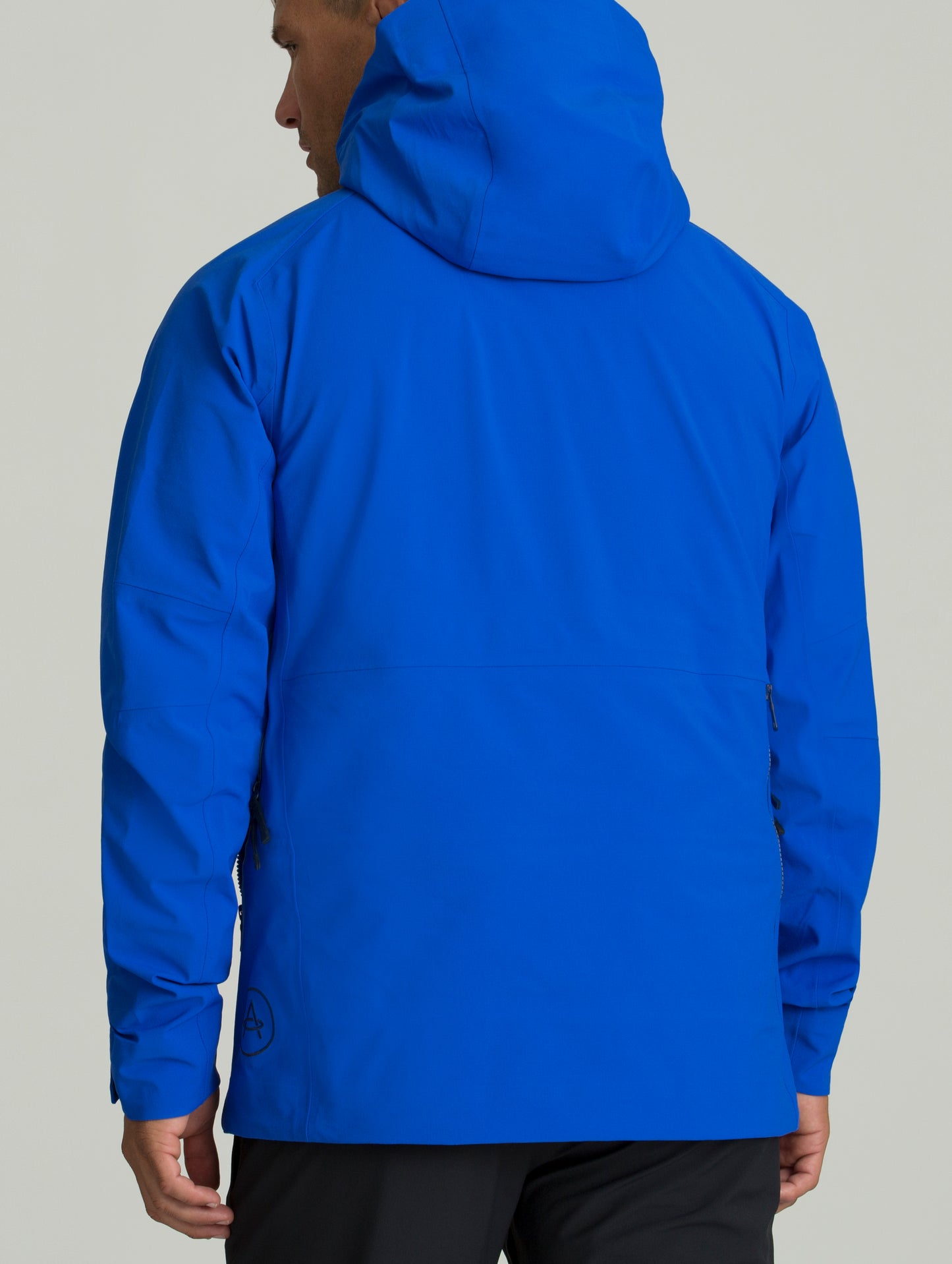 Back view of man wearing blue Access Shell from AETHER Apparel.