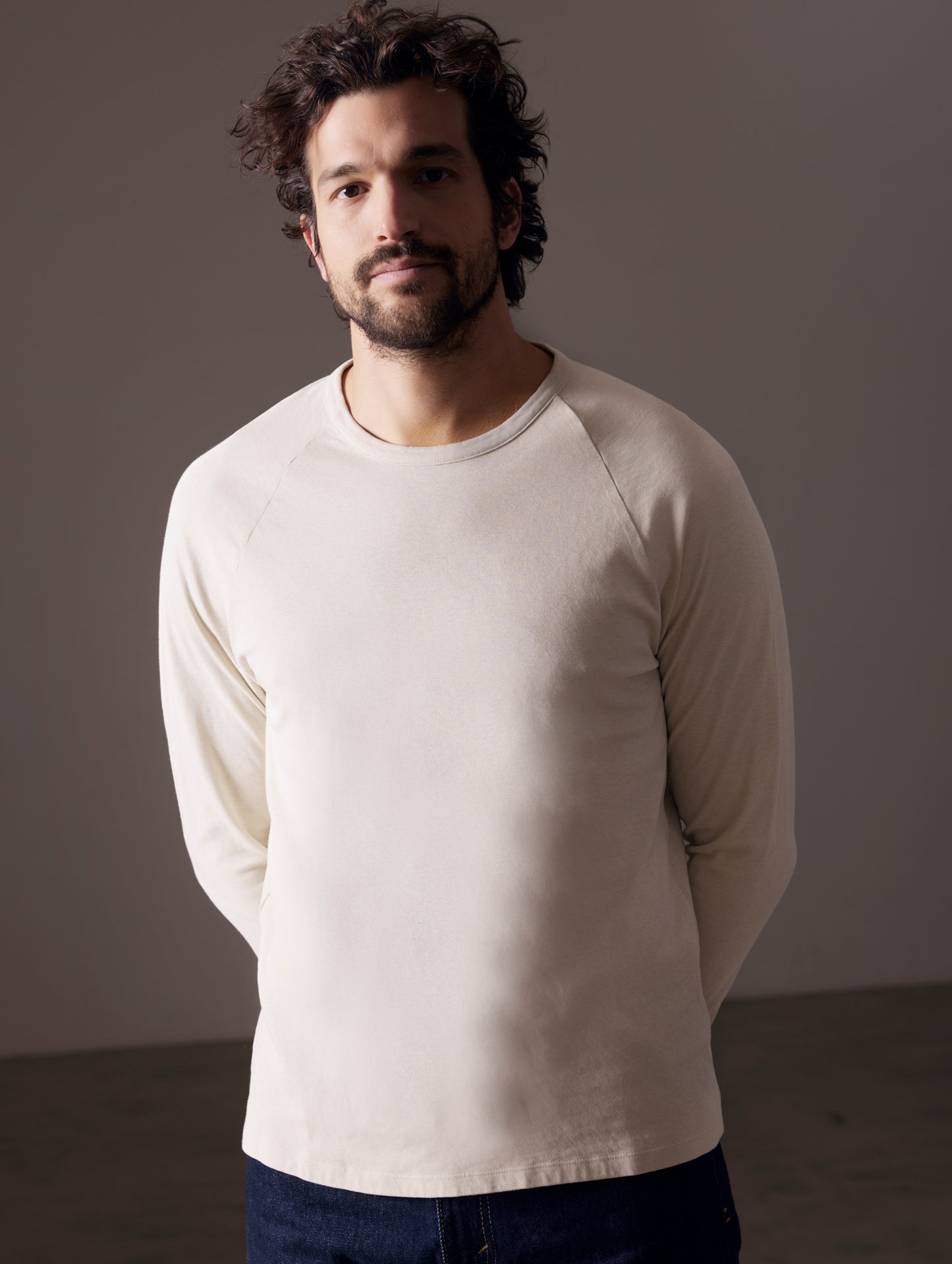 Front body view of man wearing Buckhorn Cotton Raglan Long-Sleeve Tee in Bone white from AETHER Apparel.