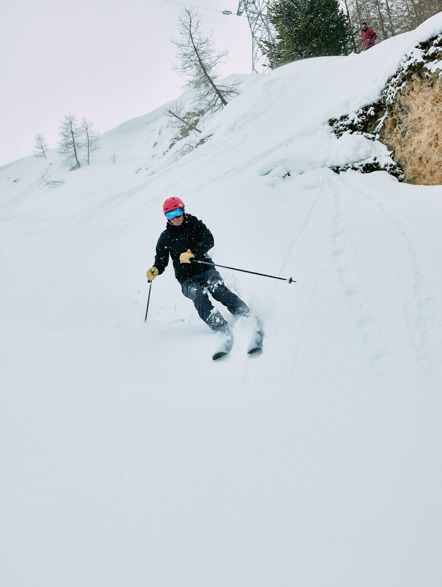 Outdoor lifestyle image of man skiing down hill wearing Catalyst Snow Shell in Charcoal Dark Heather from AETHER Apparel.