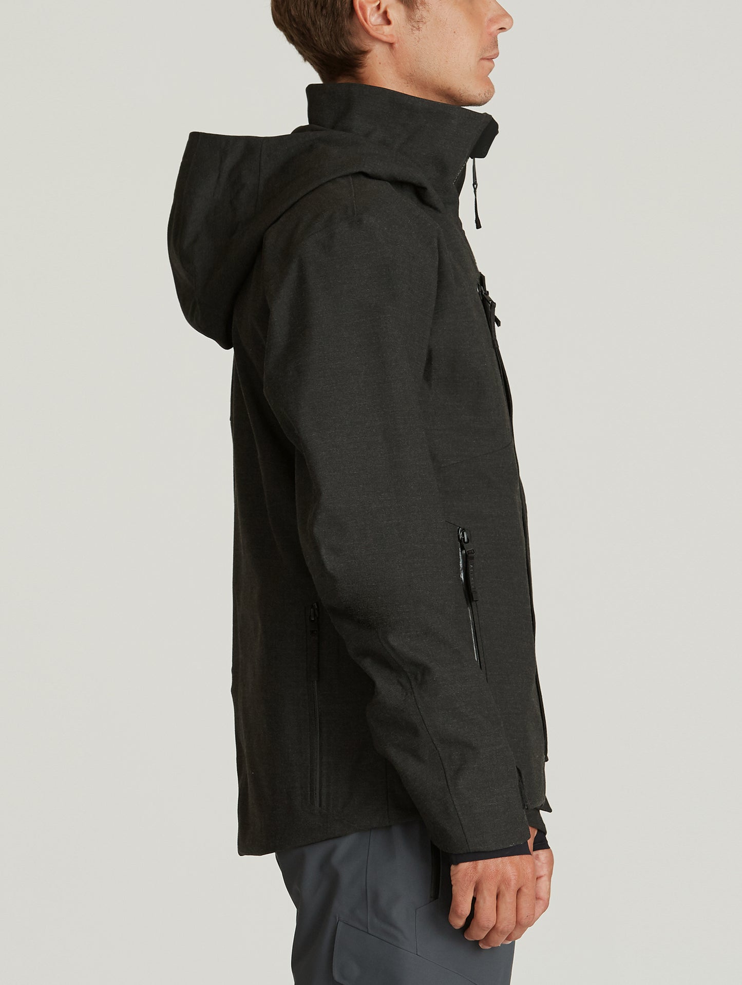 Side profile body view of man wearing Catalyst Snow Shell in Charcoal Dark Heather from AETHER Apparel.