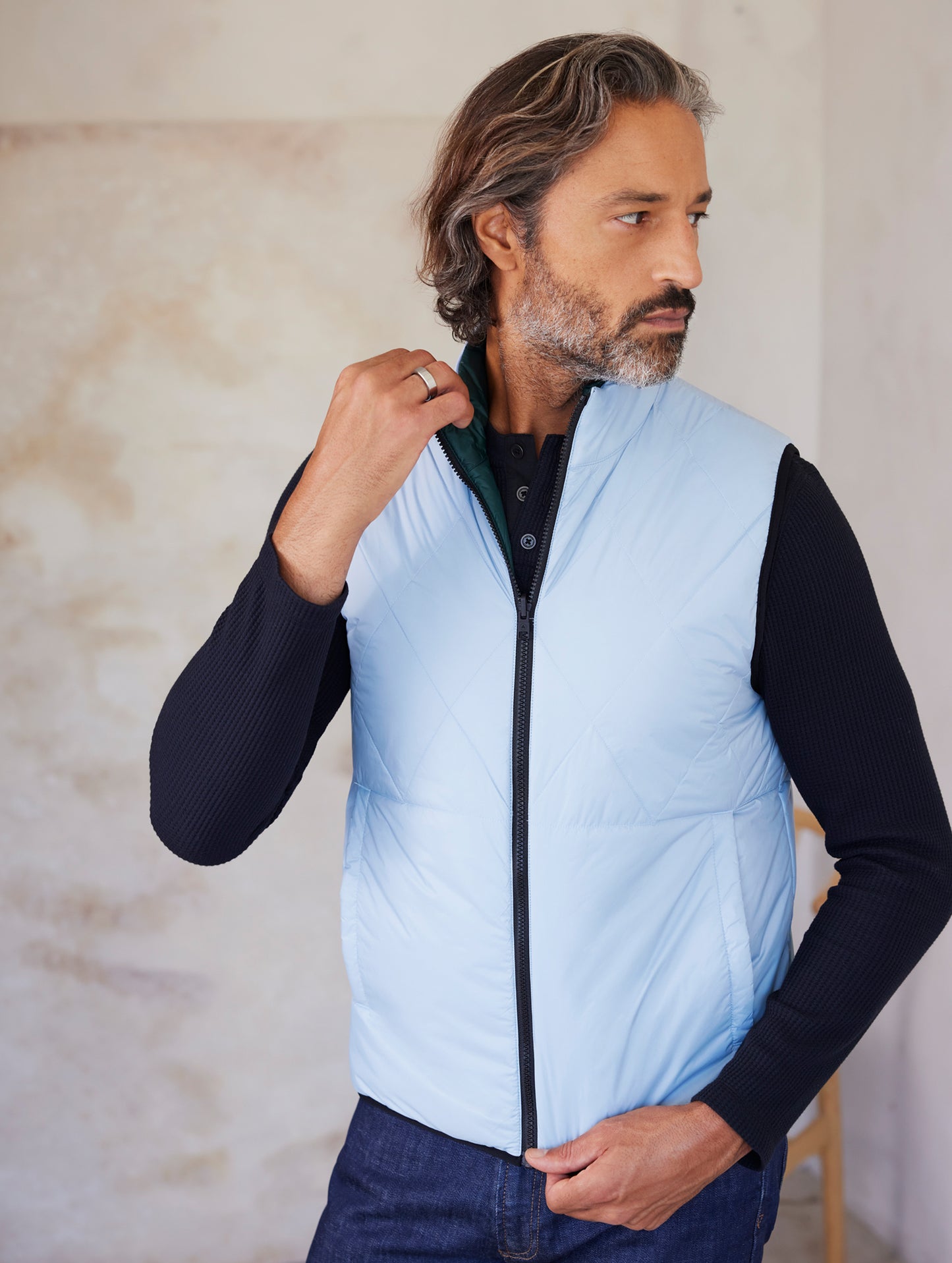 man wearing blue side of reversible insulated vest