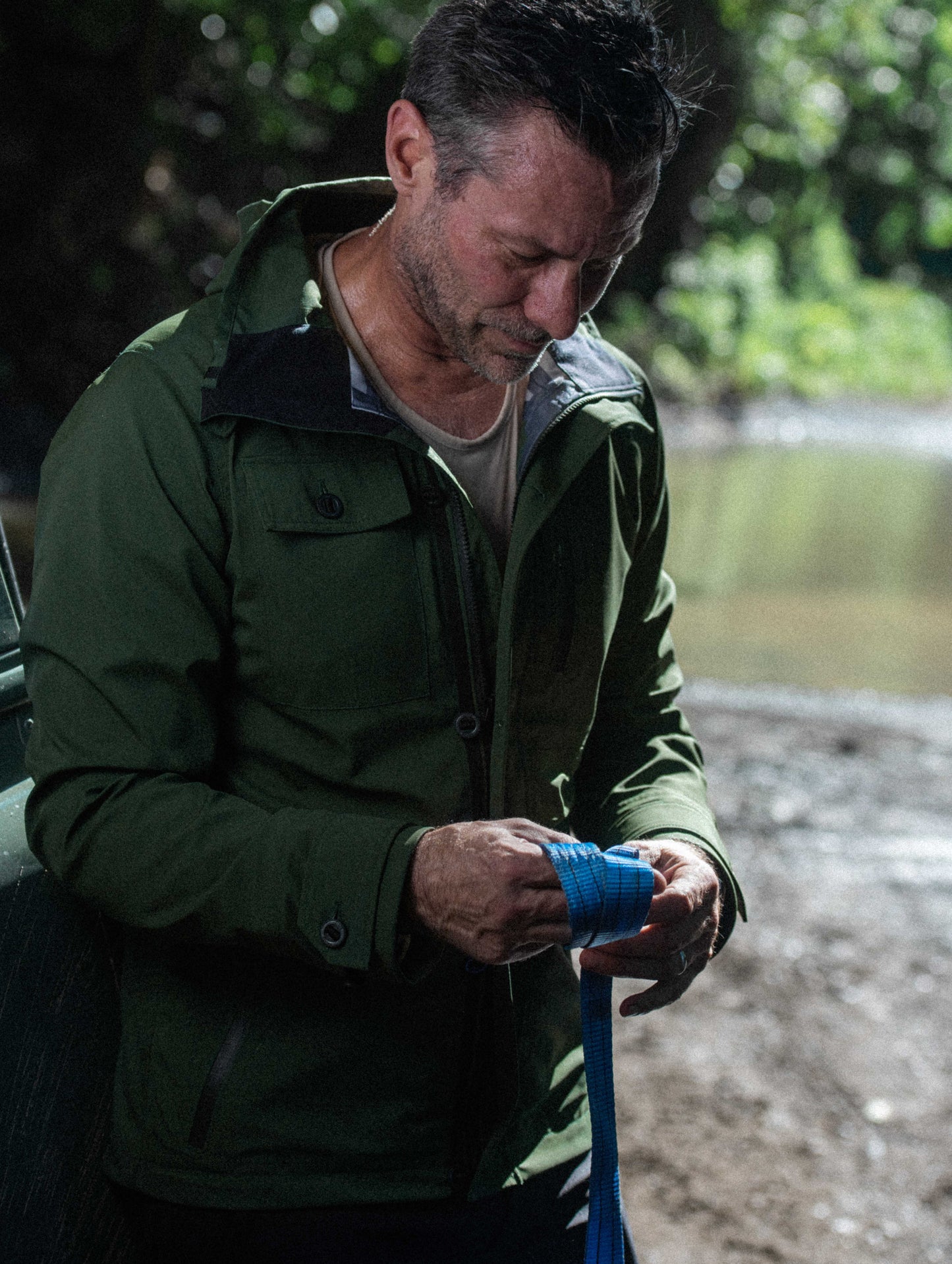Front 3/4 outdoor lifestyle image of man wearing Endeavor Jacket in Duffle Green from AETHER Apparel.