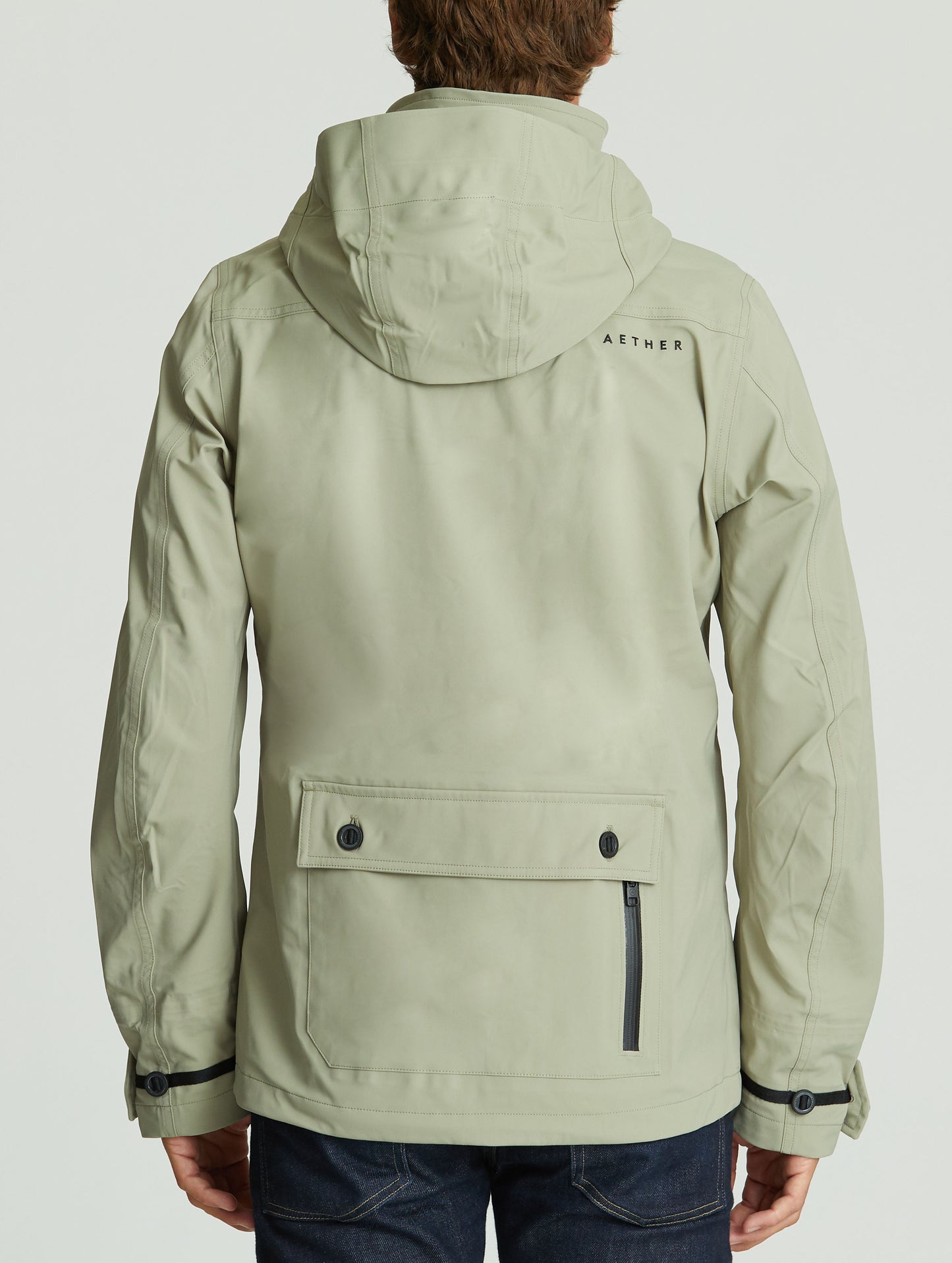 Rear body view of man wearing Endeavor Jacket in Vetiver light green from AETHER Apparel.