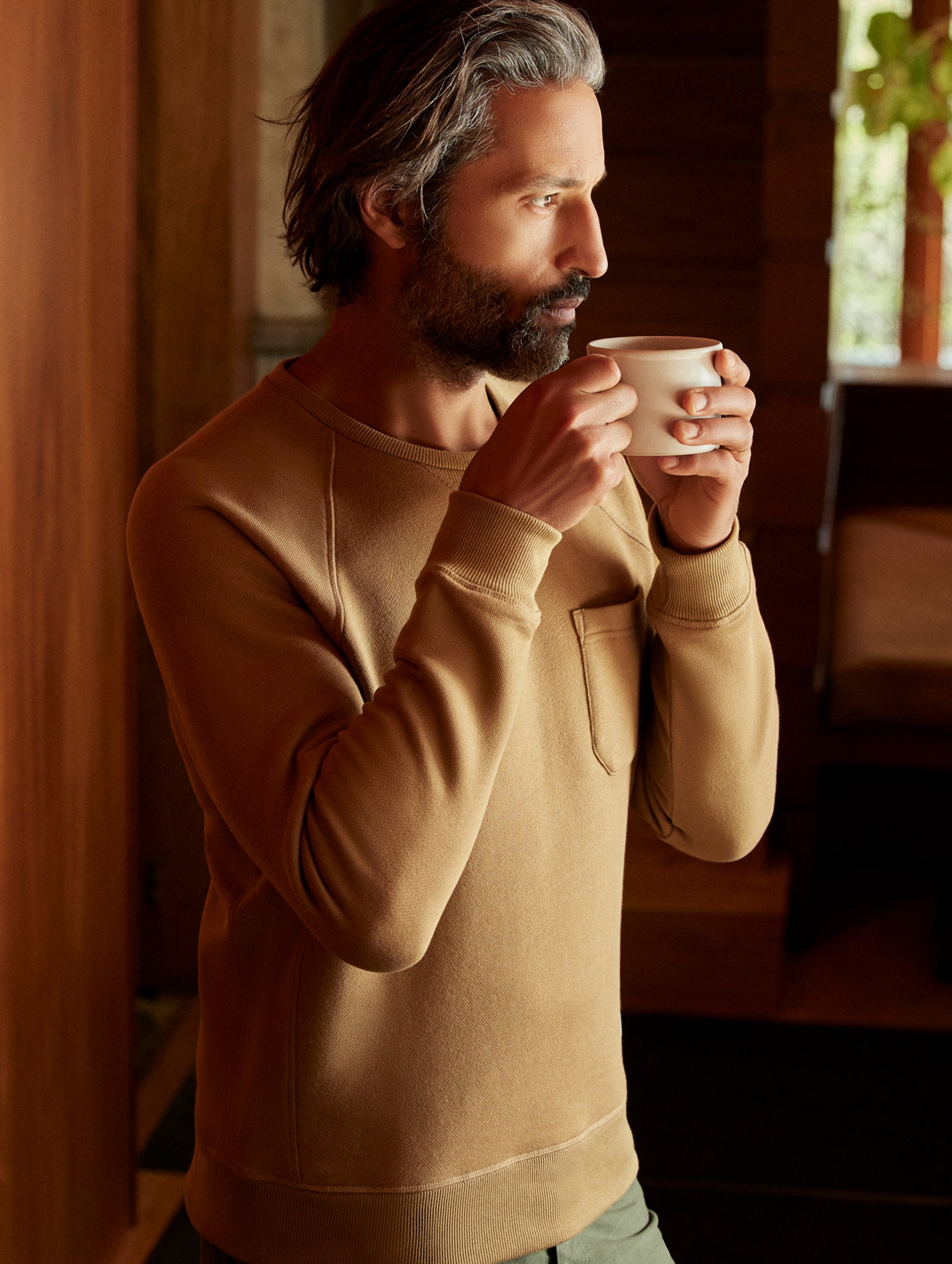 man wearing a brown crew neck with pocket