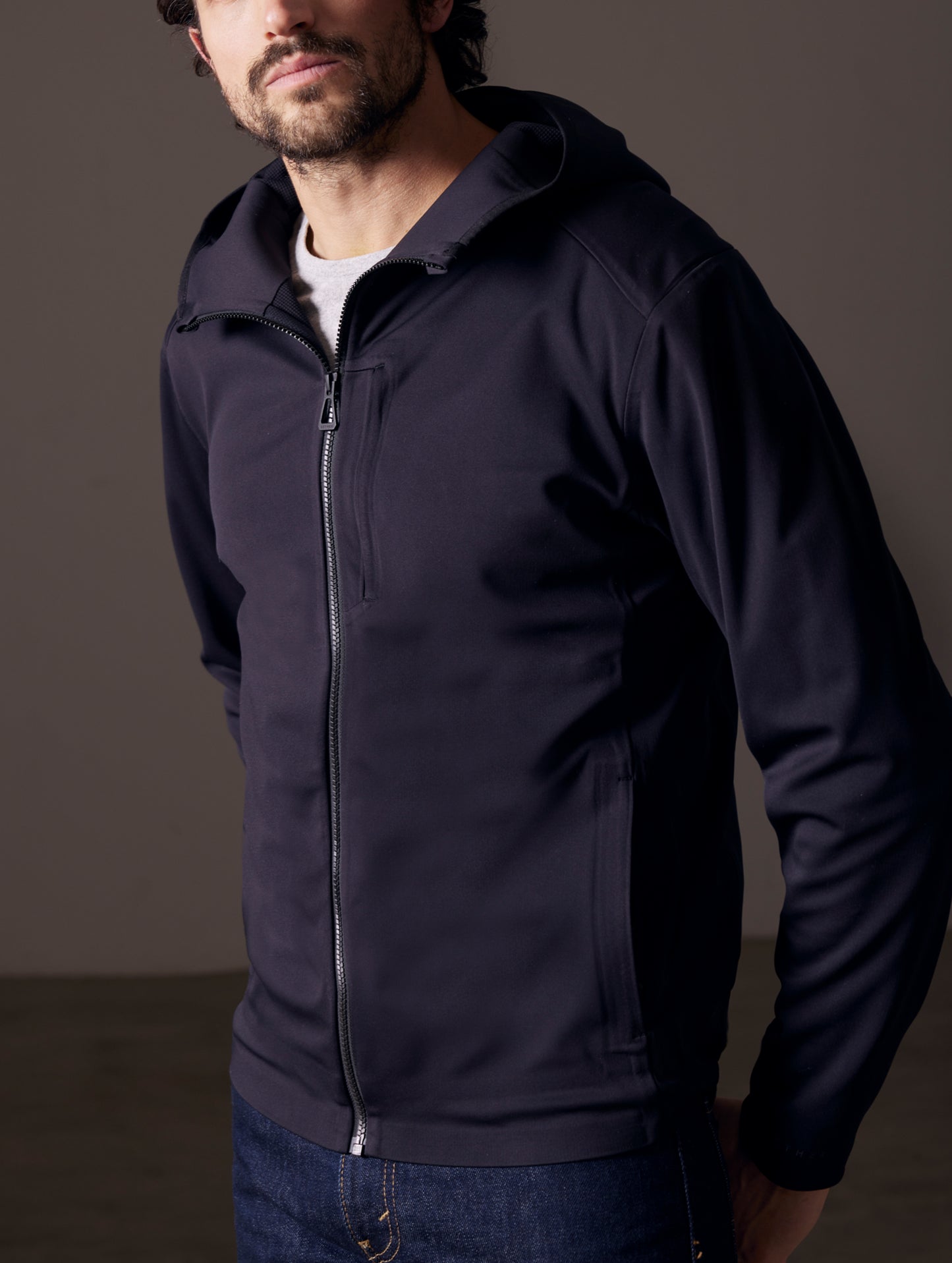 Front 3/4 body view of man wearing Hooded Tech-Fleece Full-Zip in Onyx Black from AETHER Apparel.