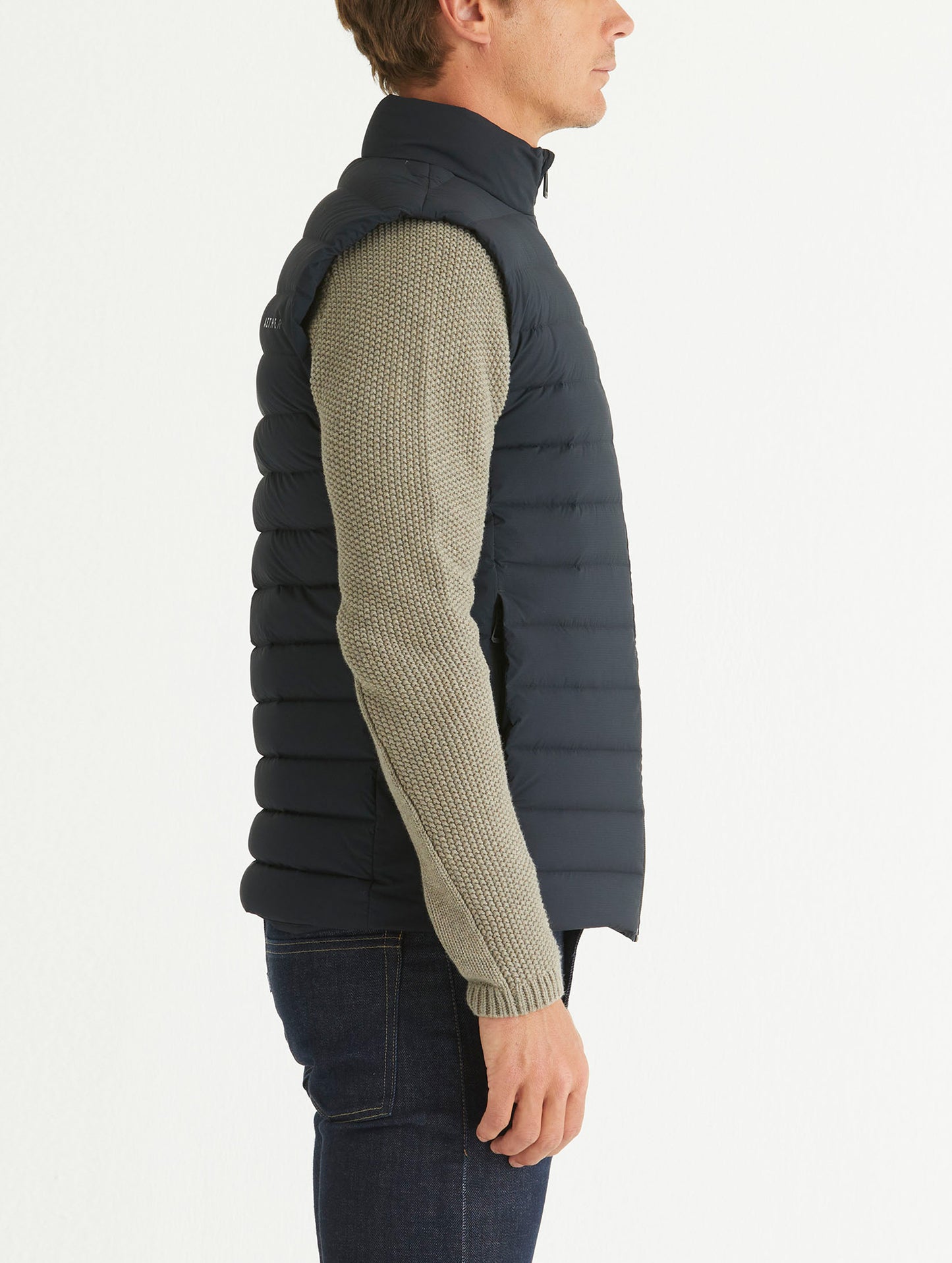 Side profile body view of man wearing Launch Vest in Onyx Black from AETHER Apparel.