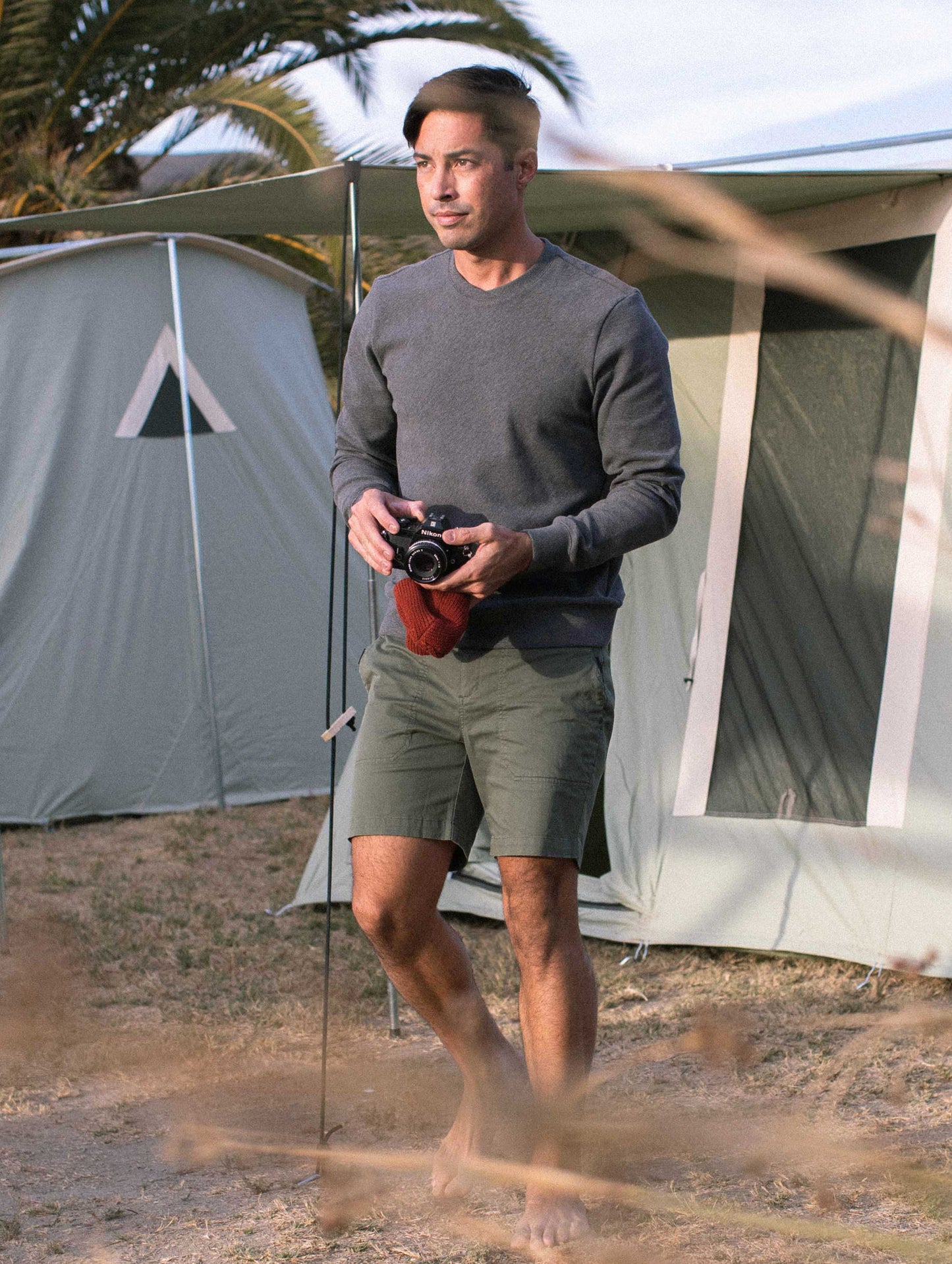 man holding camera wearing grey pullover