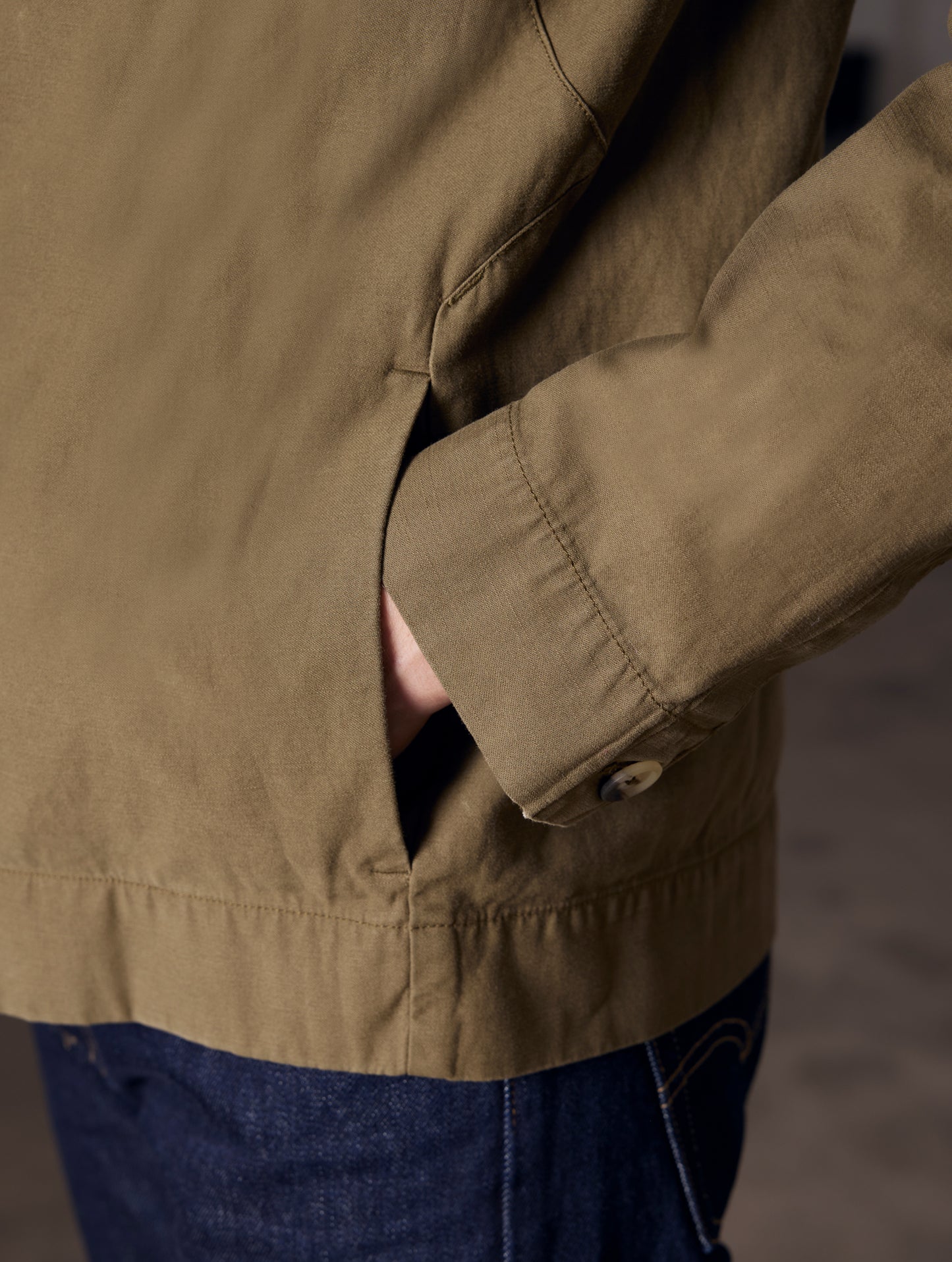 Closeup detaied view of man with hand in pocket of Mesa Jacket in Command Green from AETHER Apparel.