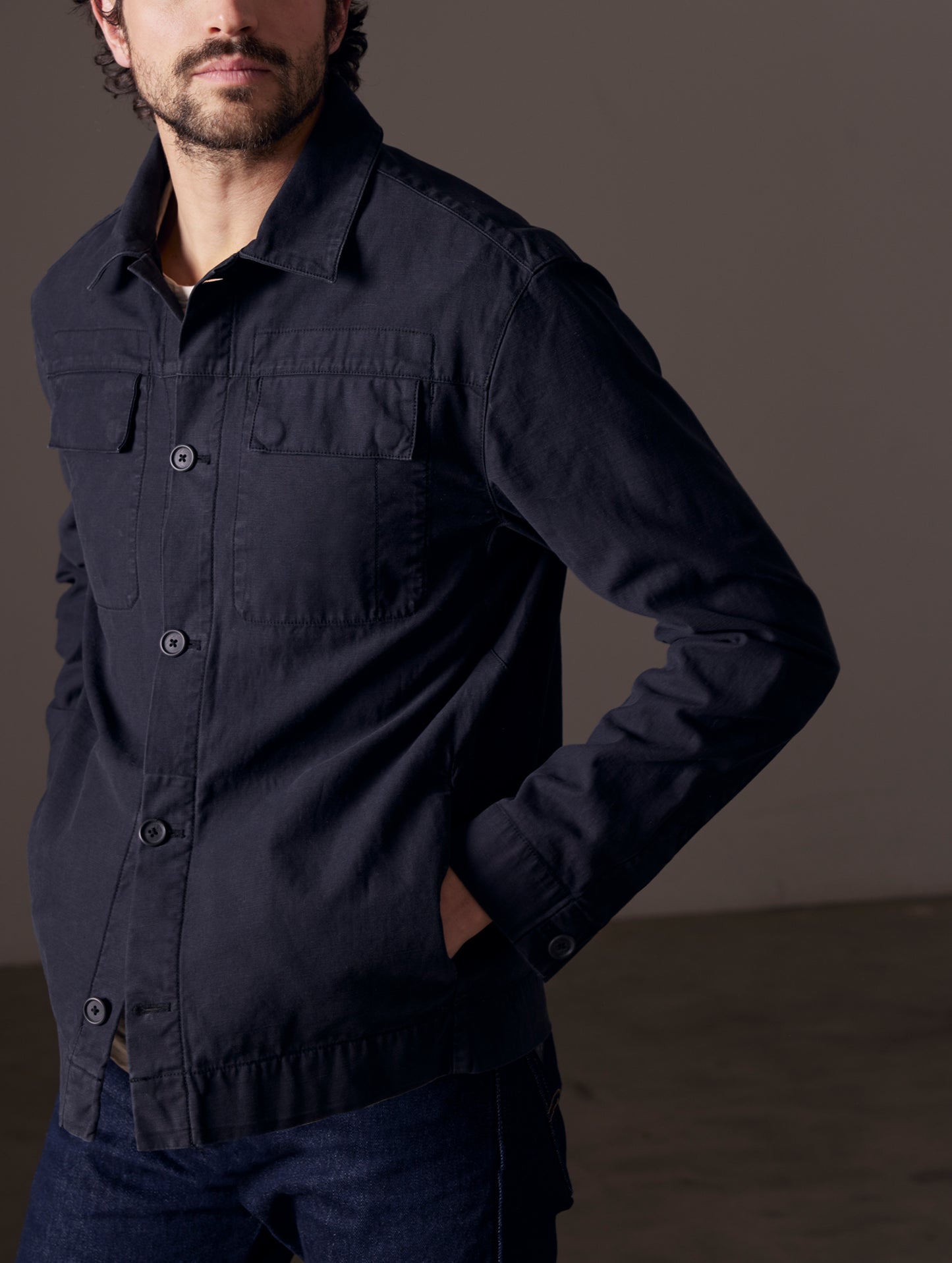 Front 3/4 body view of man with hands in pockets of Mesa Jacket in Onyx Black from AETHER Apparel.