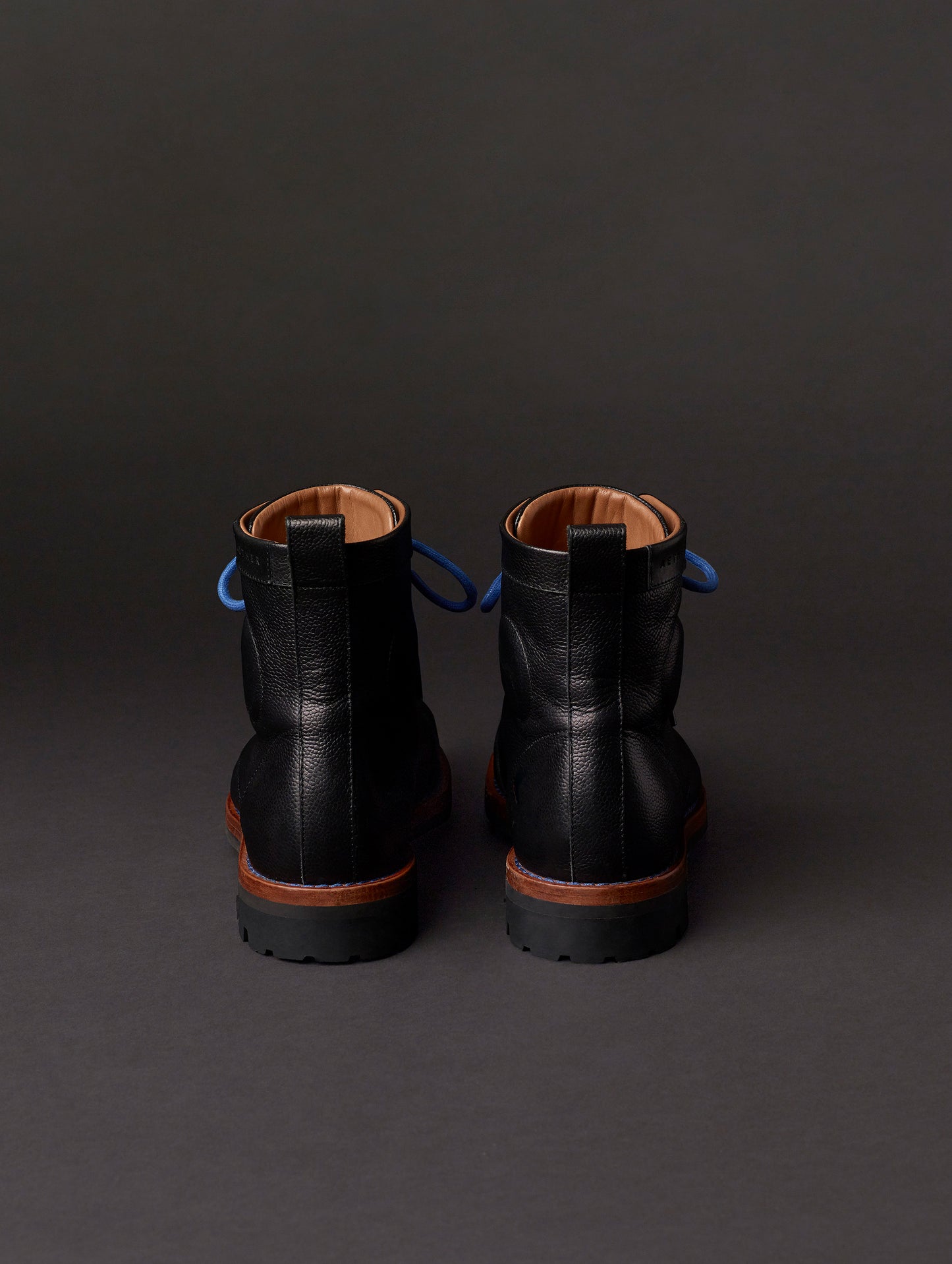 Rear view of AETHER Moto Boot in Jet Black with blue laces from AETHER Apparel.