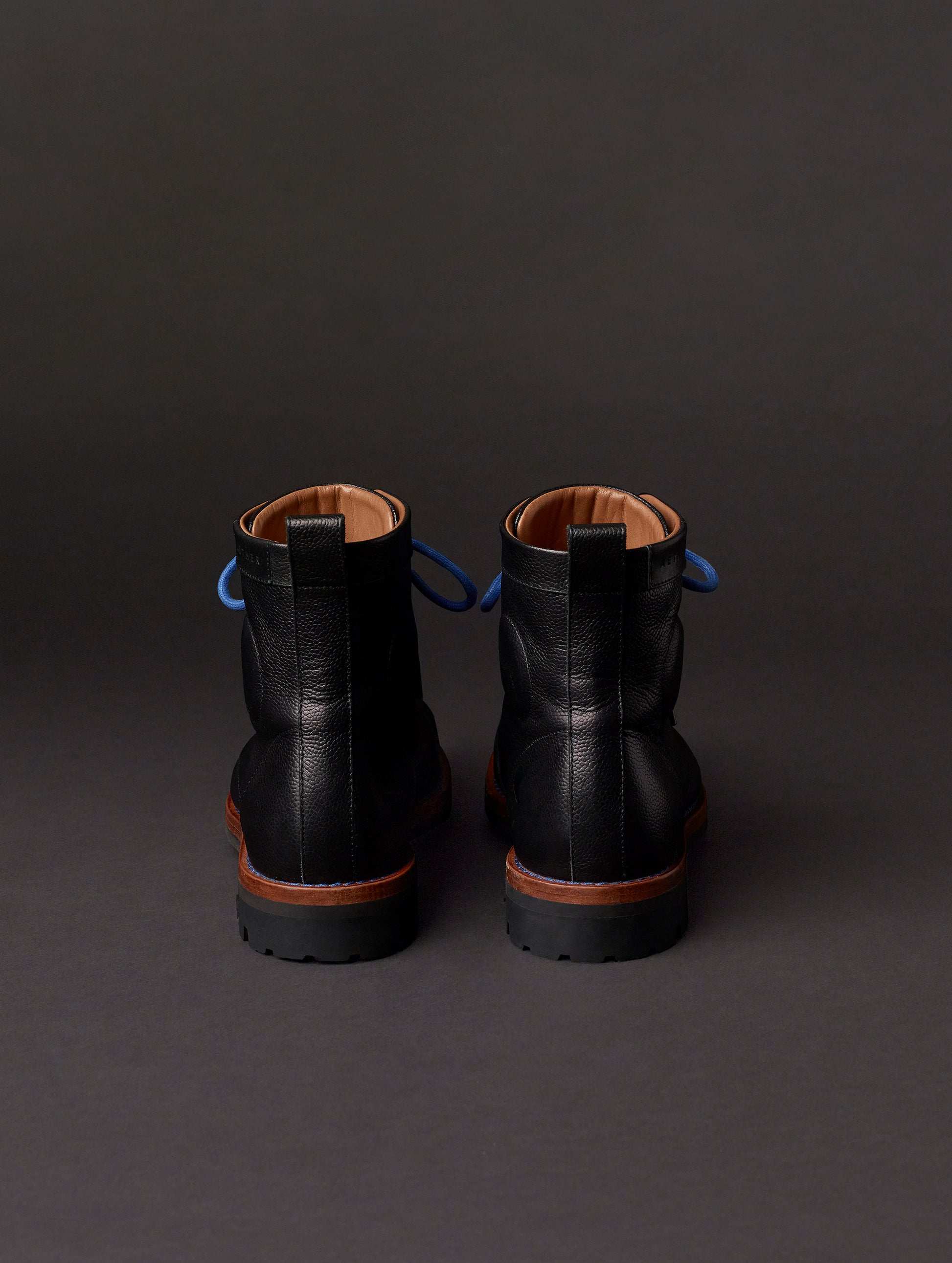Rear view of AETHER Moto Boot in Jet Black with blue laces from AETHER Apparel.