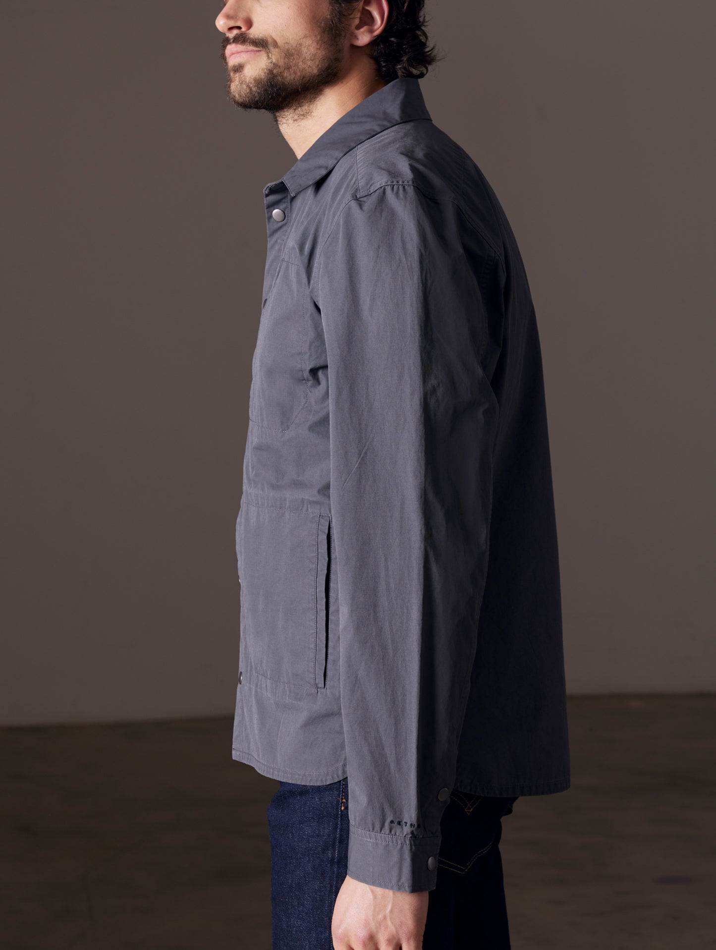 Side profile body view of man wearing Pine Shacket in Graphite from AETHER Apparel.
