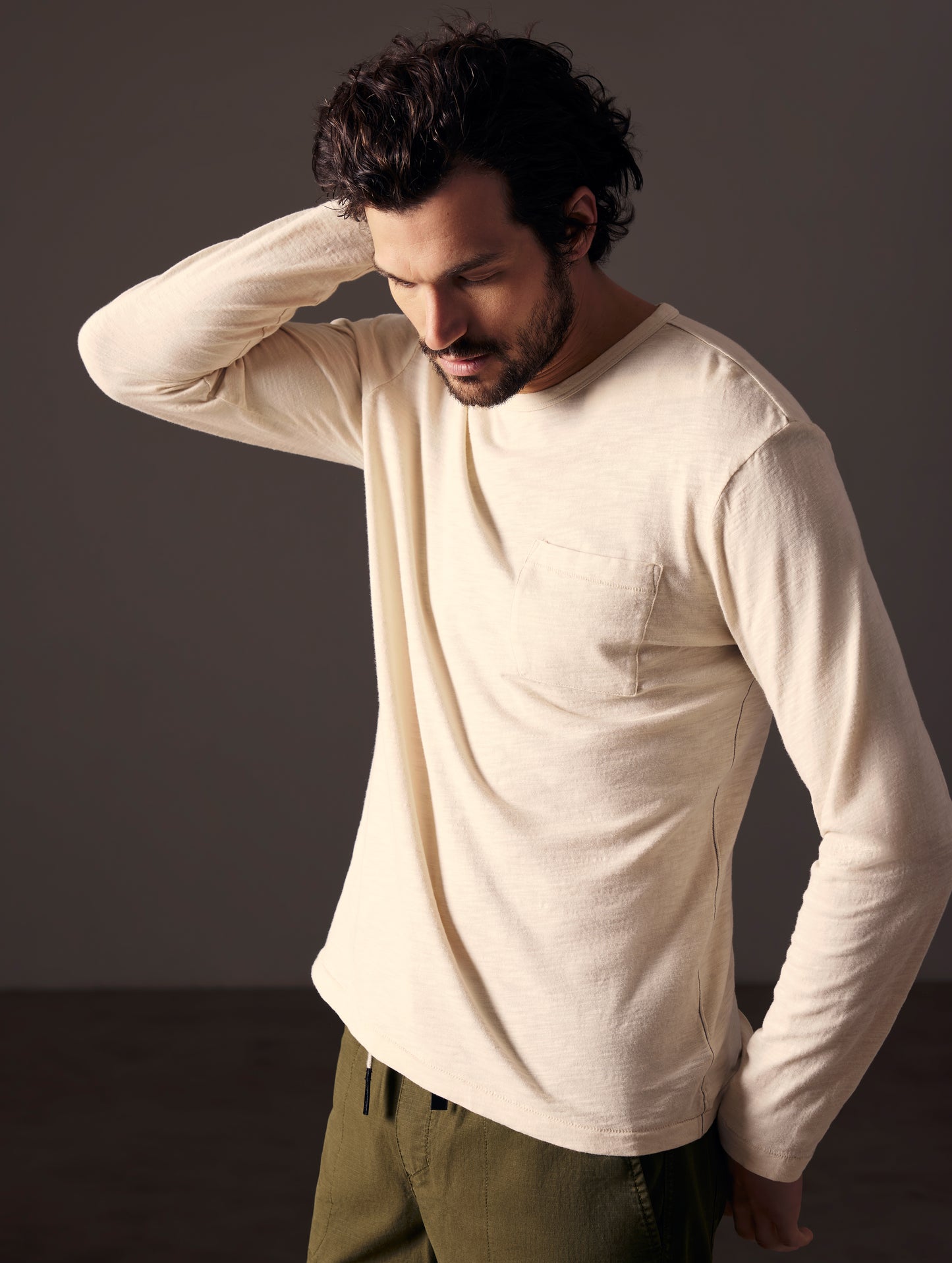 Front angled body view of man wearing Slub Long-Sleeve Tee in Bone white from AETHER Apparel.