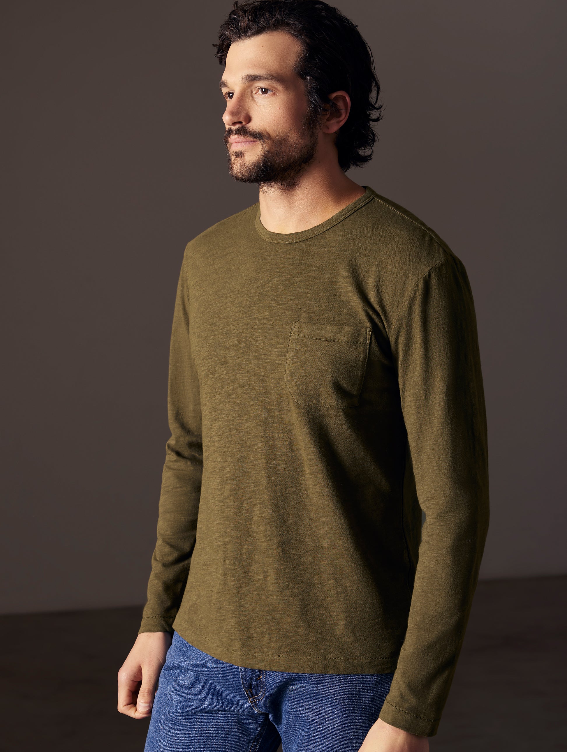 Front angled body view of man wearing Slub Long-Sleeve Tee in Command Green from AETHER Apparel.