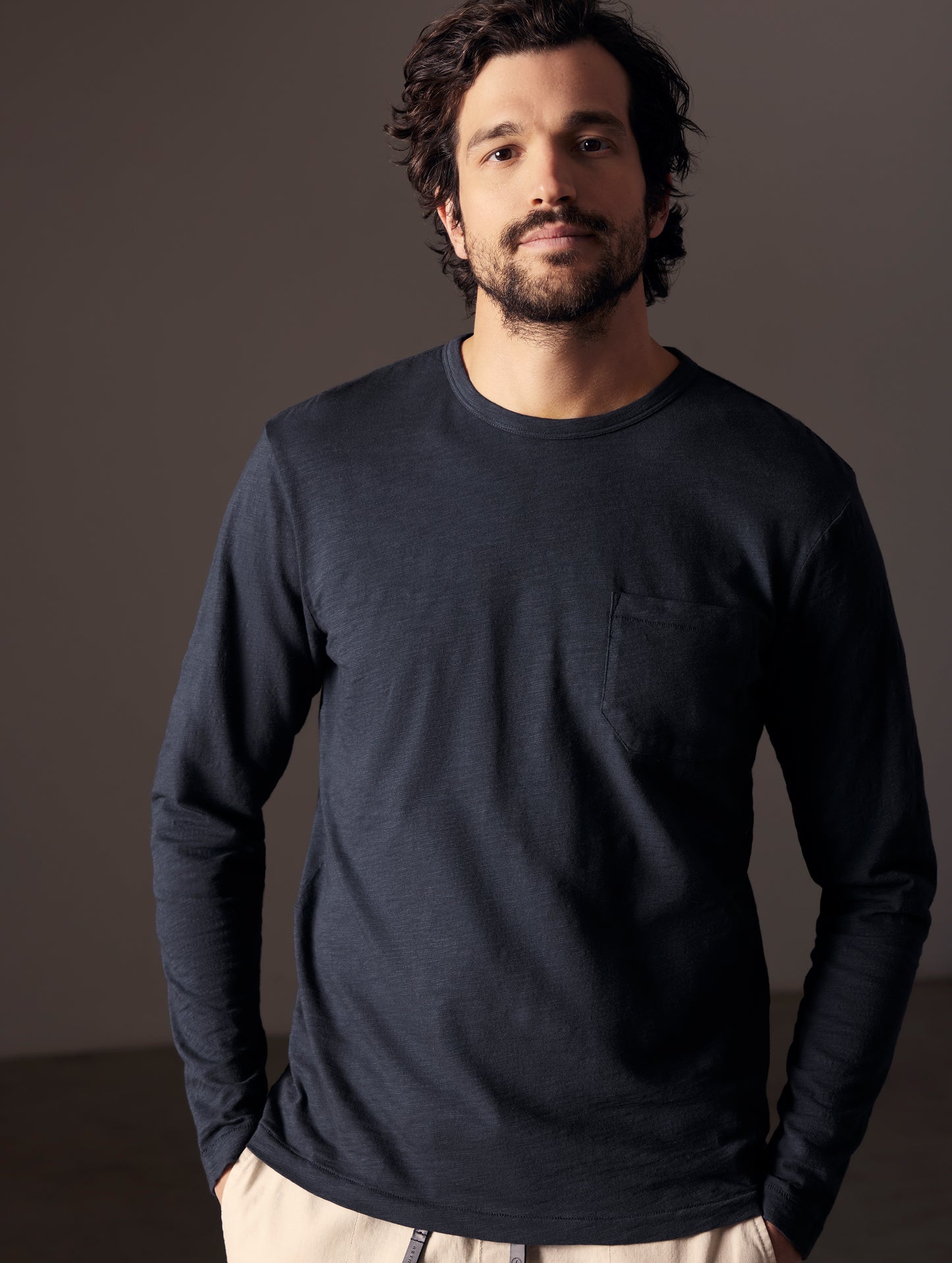 Front body view of man wearing Slub Long-Sleeve Tee in Total Eclipse dark blue from AETHER Apparel.