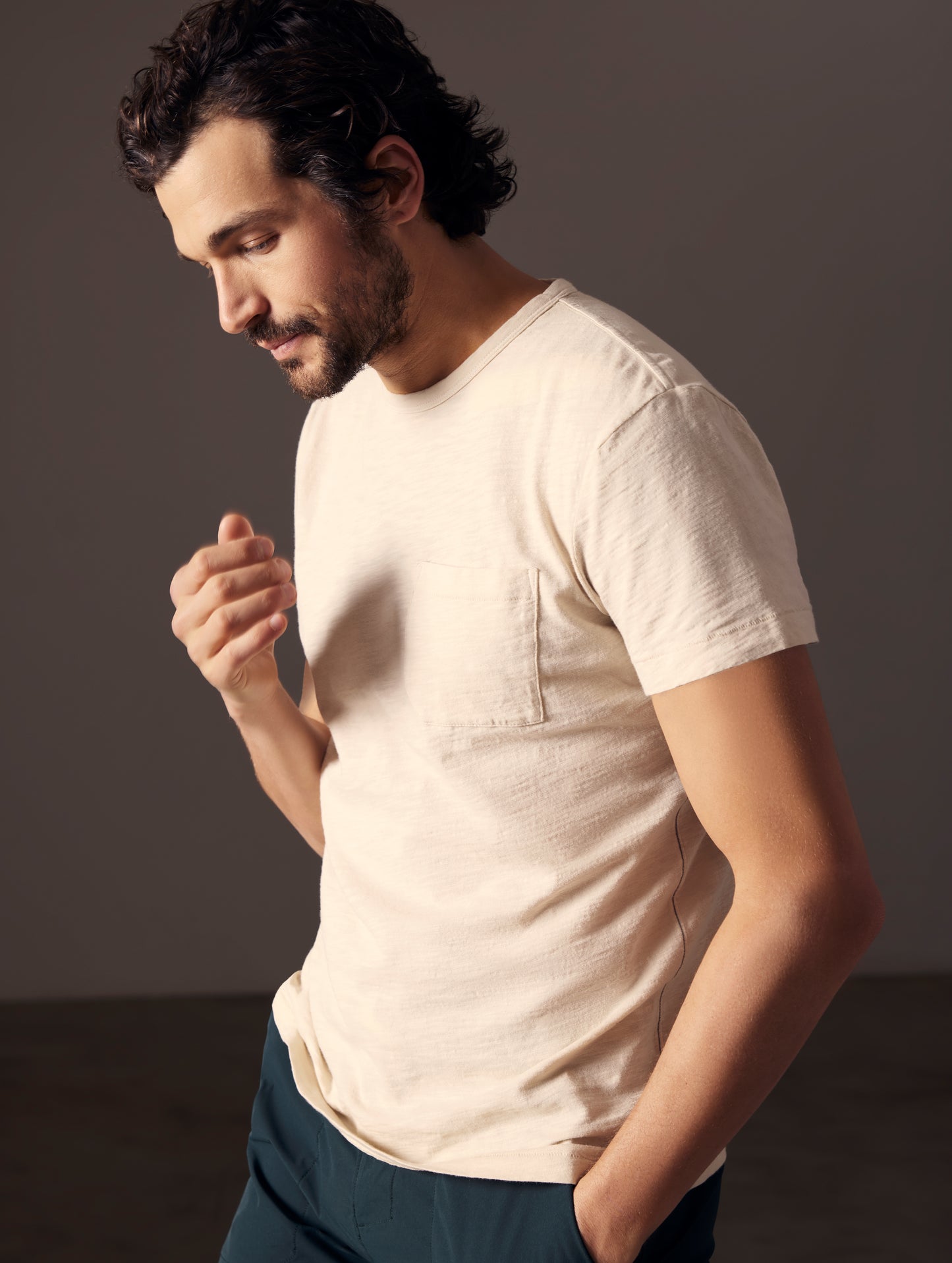 Front angled body view of man wearing Slub Pocket Tee in Bone white from AETHER Apparel.