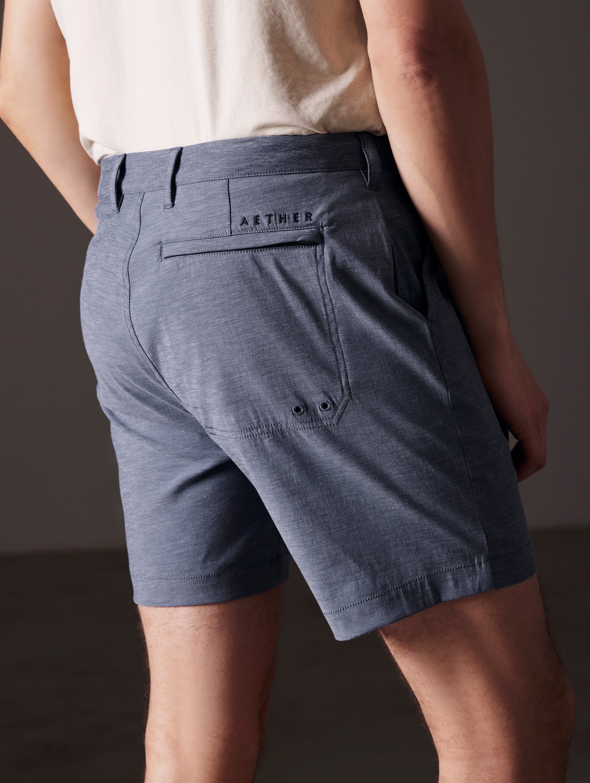 Rear angled lower body view of man wearing Strand Hybrid Swim Short 7" in Slate Heather from AETHER Apparel.