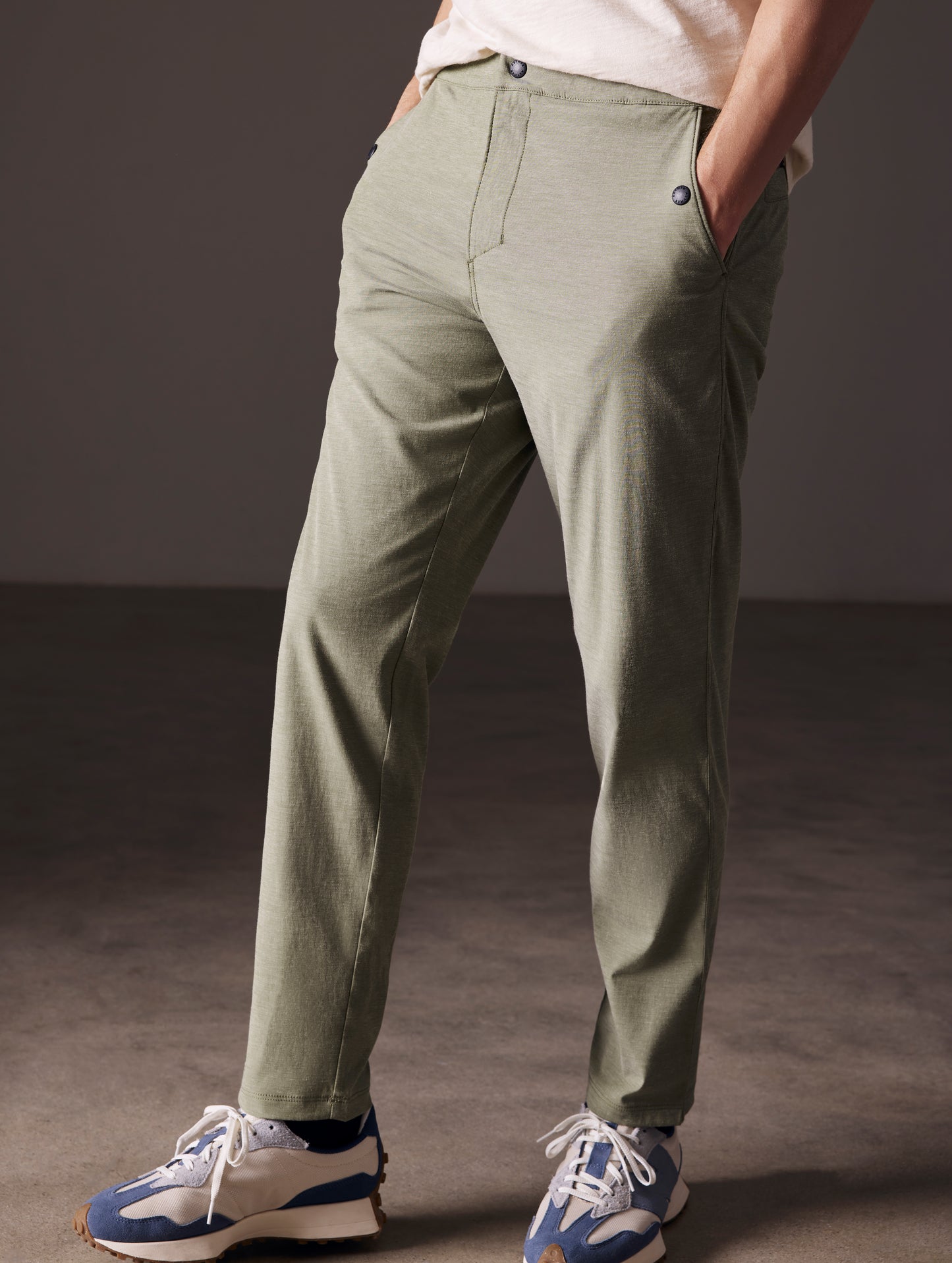 Front angled lower body view of man wearing Strand Tech Pant in Command Green from AETHER Apparel.
