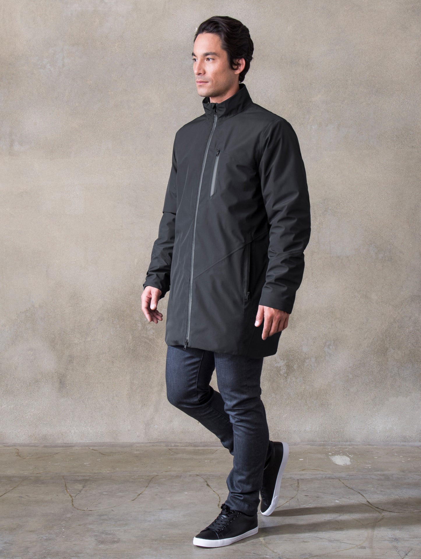 Full-body angled view of man wearing black Tundra Jacket from ATHER Apparel.