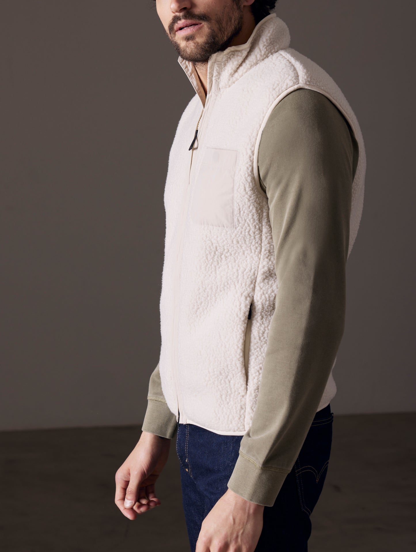 Side profile body view of man wearing Walsh Vest in Bone white from AETHER Apparel.