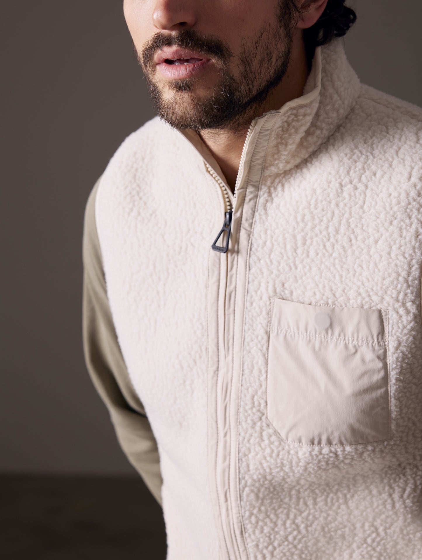 Closeup detailed view of main zipper, chest pocket, and fabric of Walsh Vest in Bone white from AETHER Apparel.