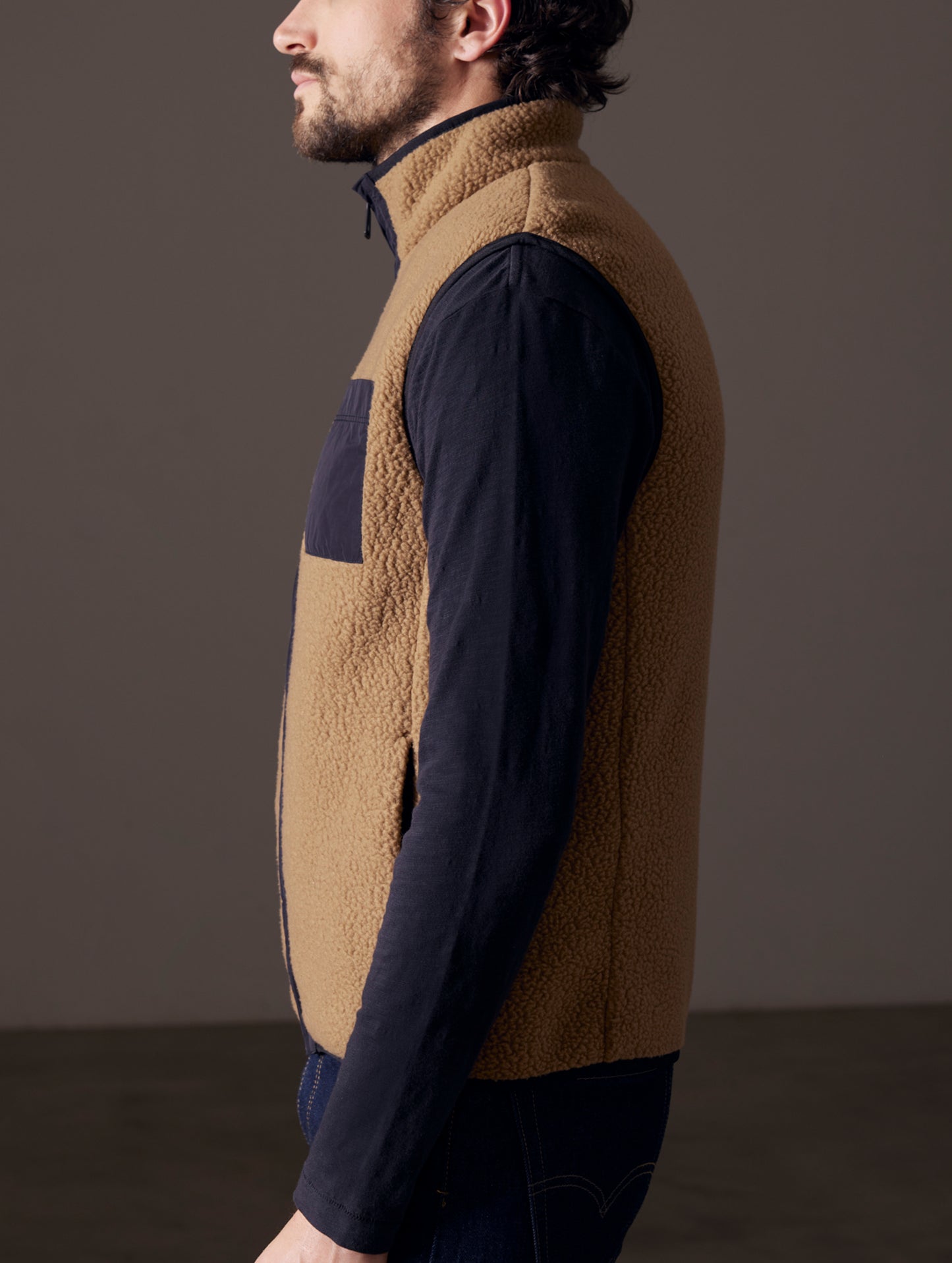 Side profile body view of man wearing Walsh Vest in Reserve Brown from AETHER Apparel.