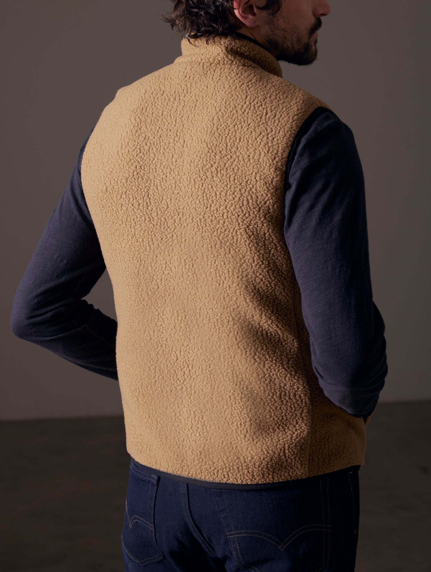 Rear 3/4 view of man wearing Walsh Vest in Reserve Brown from AETHER Apparel.