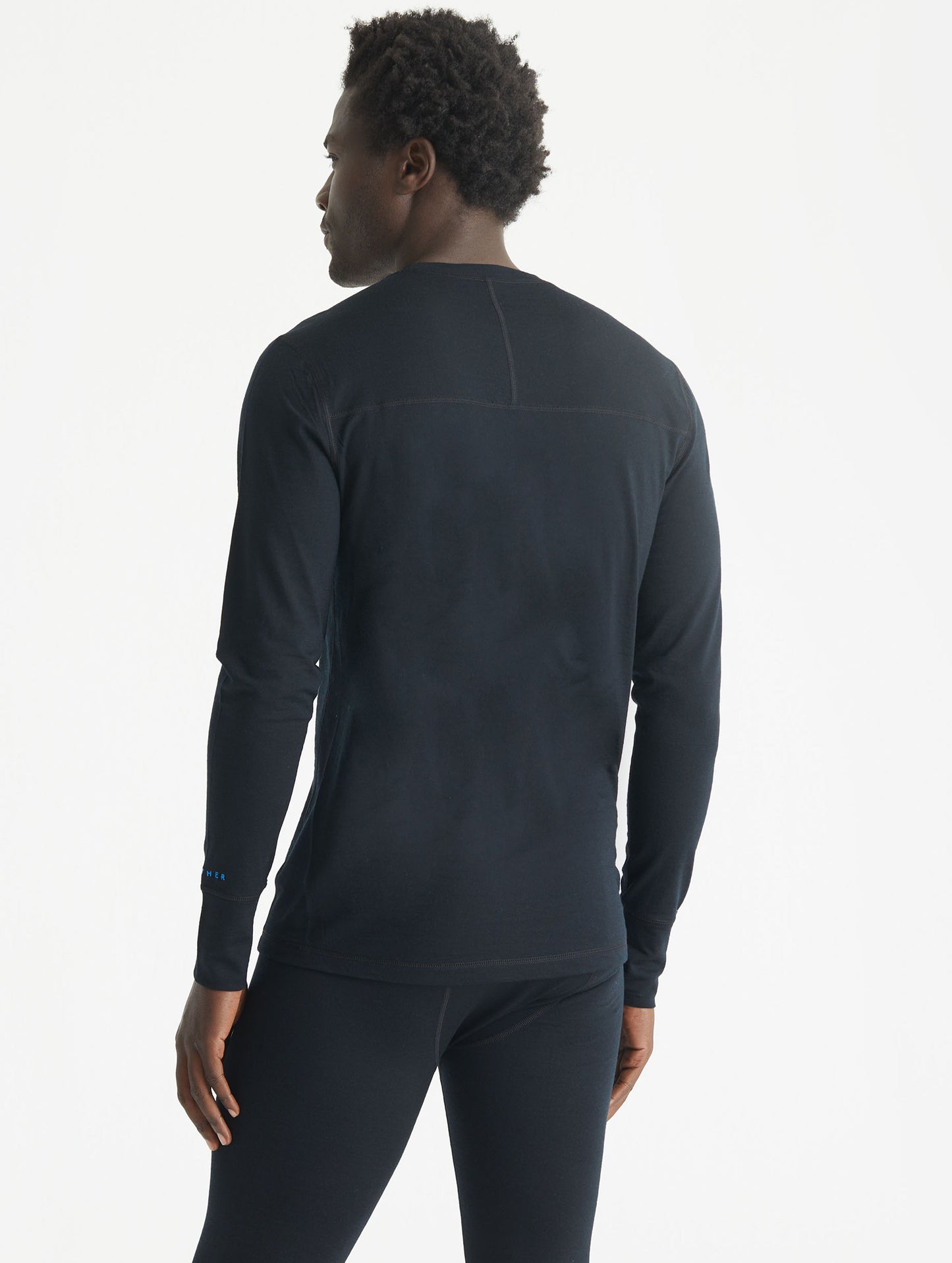 Rear 3/4 body view of man wearing Premium Merino Base Layer Crew in Jet Black from AETHER Apparel.