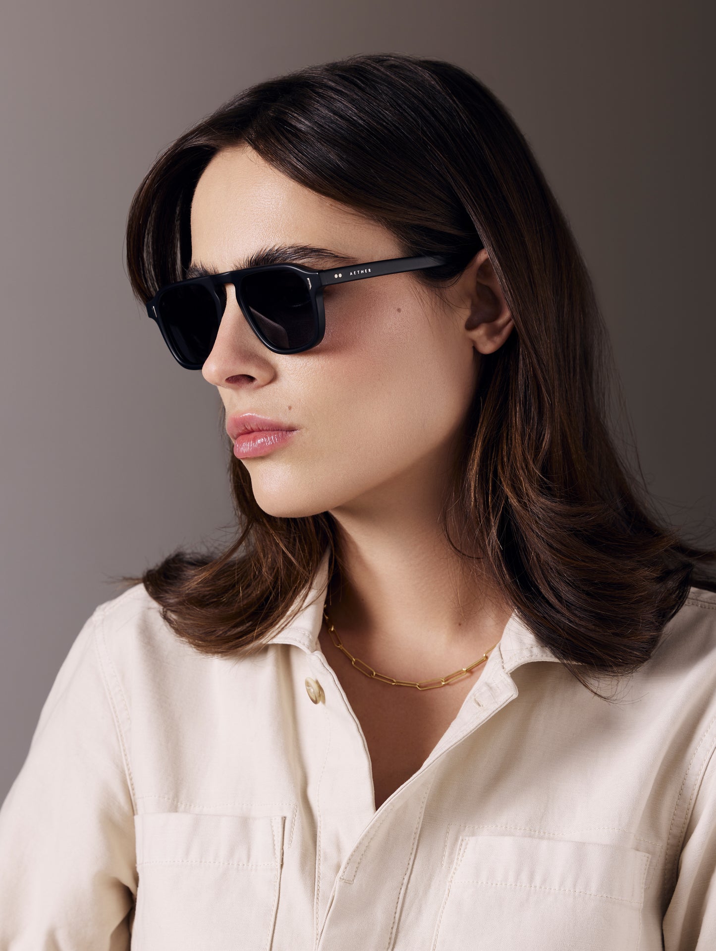 Front 3/4 view of woman wearing Sequoia Sunglass in Matte Black with Grey Lens from AETHER Apparel.