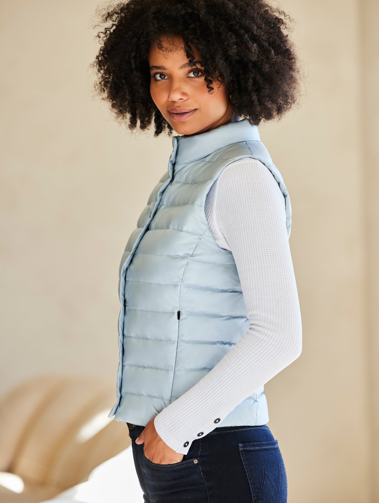 Side profile view of woman wearing Aura Vest in Flight Blue from AETHER Apparel.