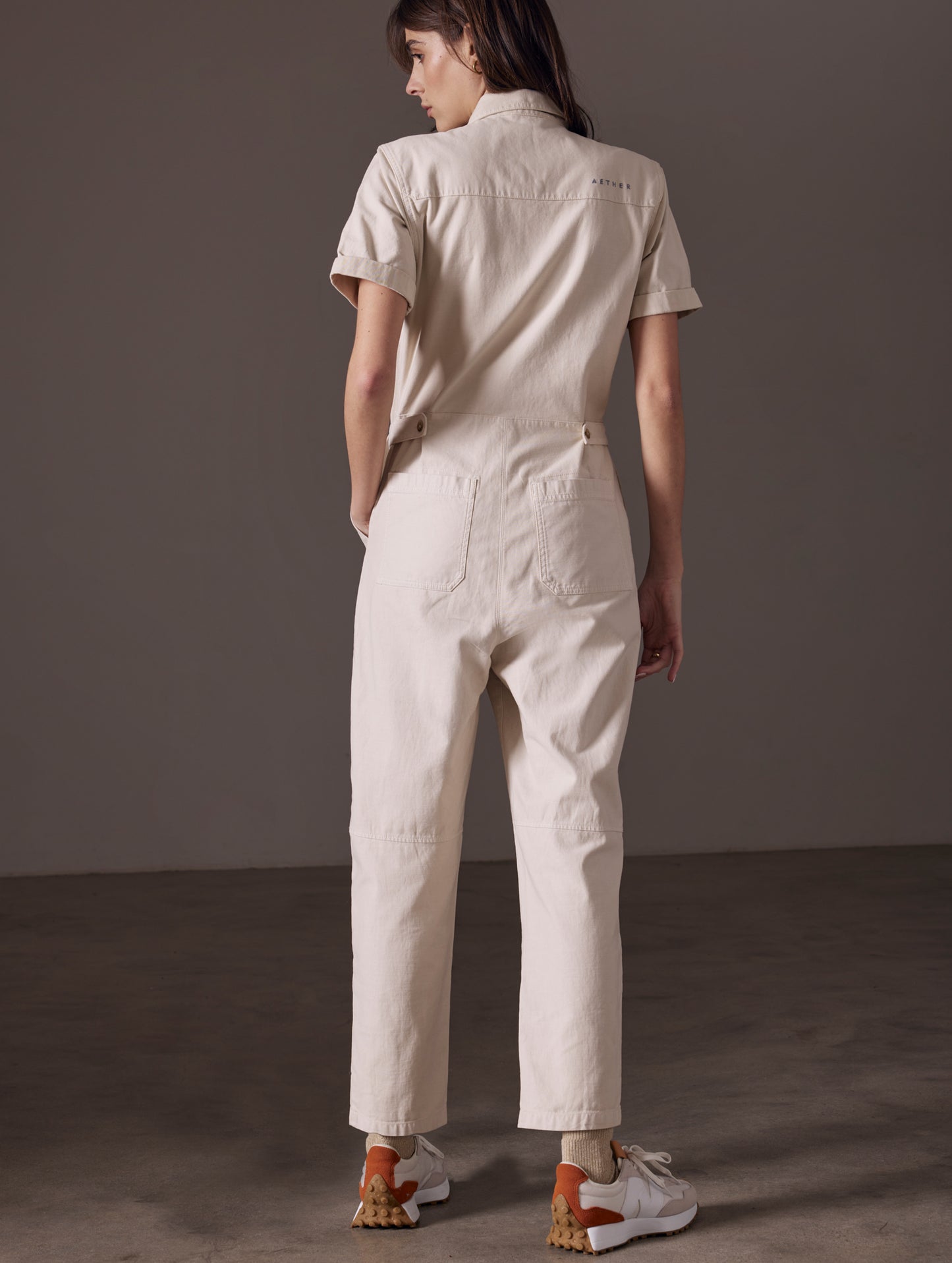 back view of woman wearing beige short-sleeve jumpsuit